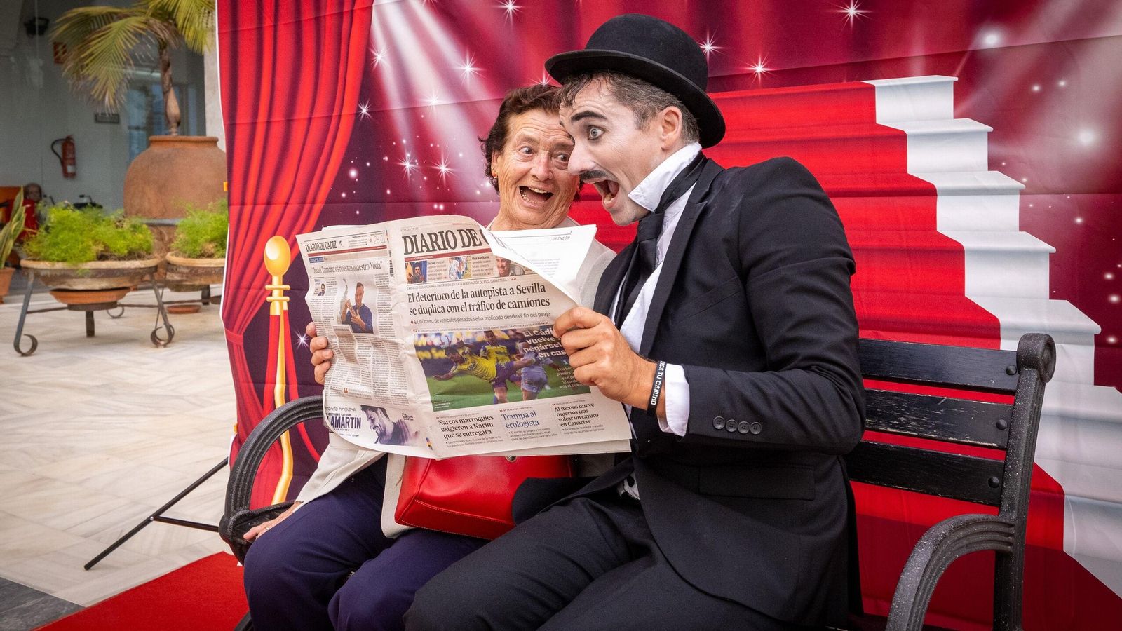 Charlot bromea con una usuaria de Fragela ante un  ejemplar de Diario de Cádiz.