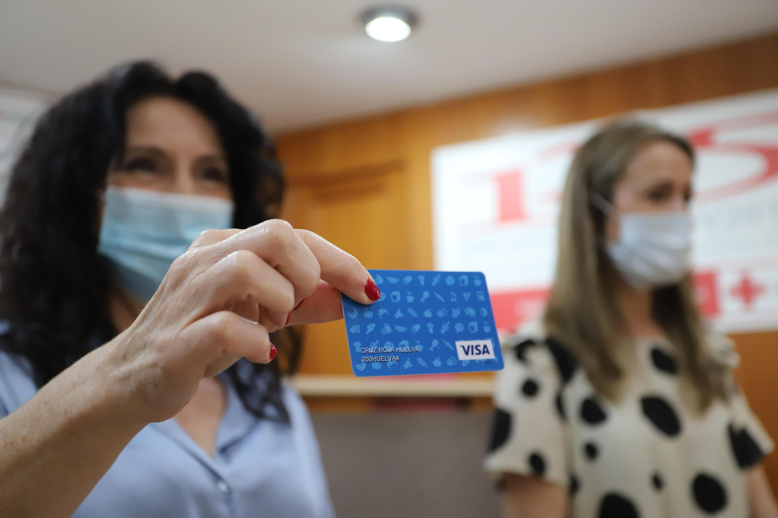 La consejera Rocío Ruiz muestra en Huelva una de las tarjetas monedero que serán repartidas.