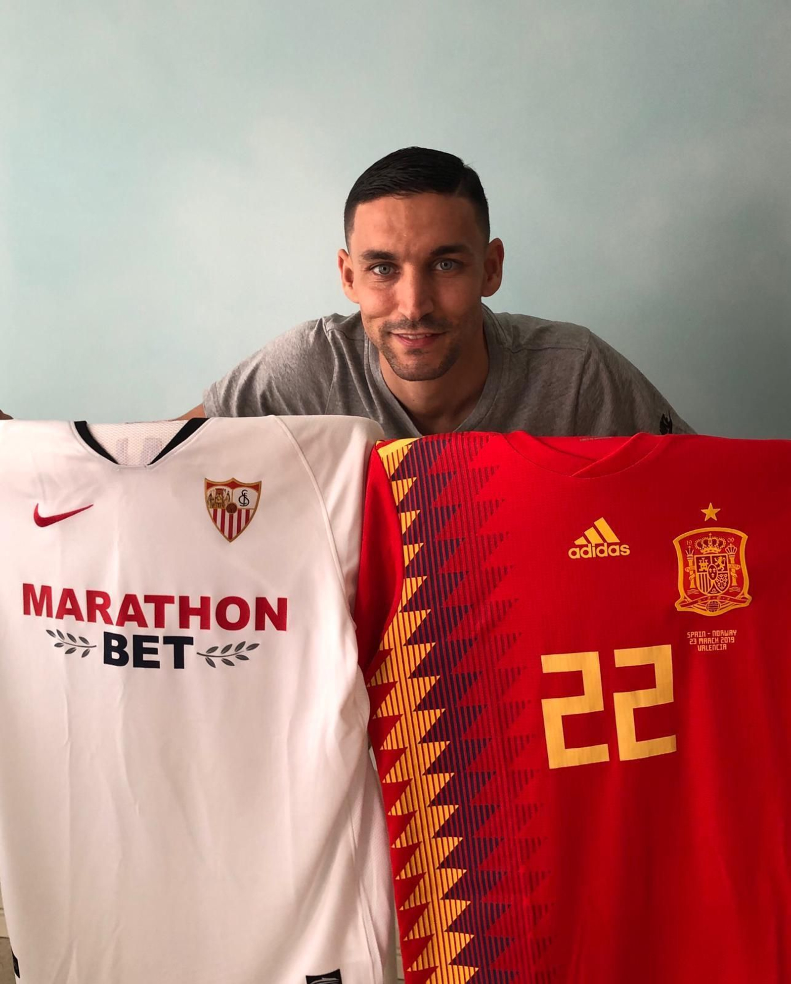 El internacional del Sevilla, con las dos camisetas que lo enorgullecen.