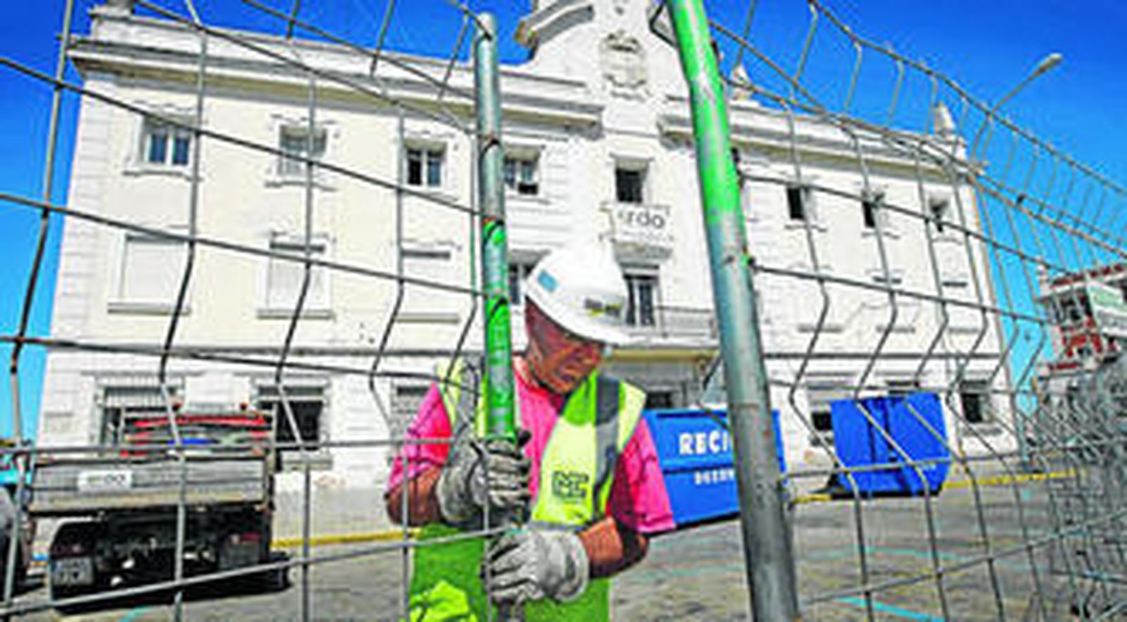 Un obrero cierra la valla que protege la obra de derribo de la antigua Comandancia de Marina.