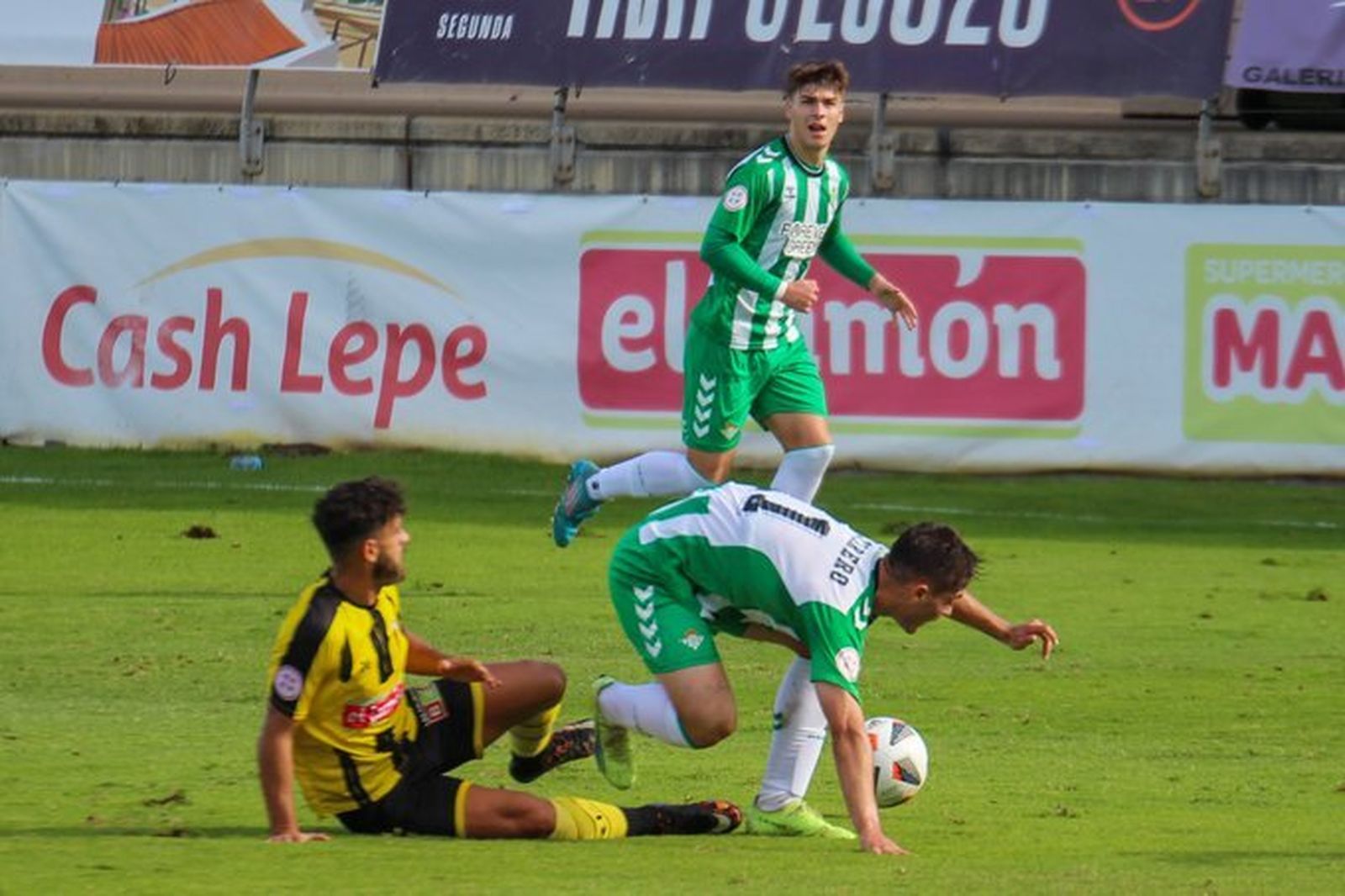 El bético Cantarero es derribado por un rival aurinegro.