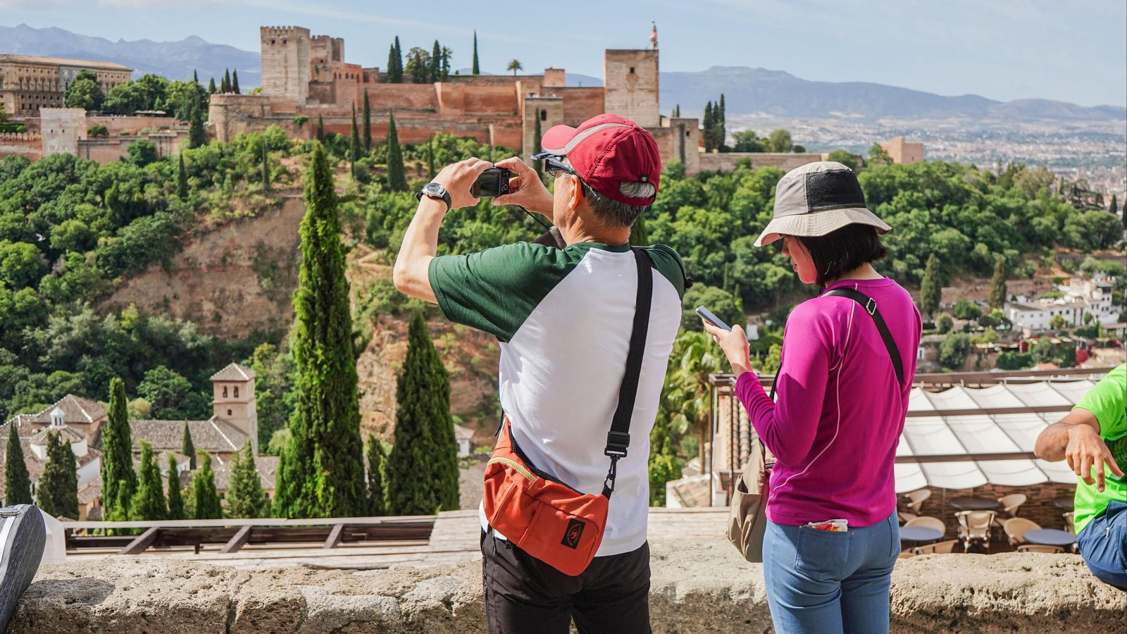Dos turistas fotografían la Alhambra de Granada