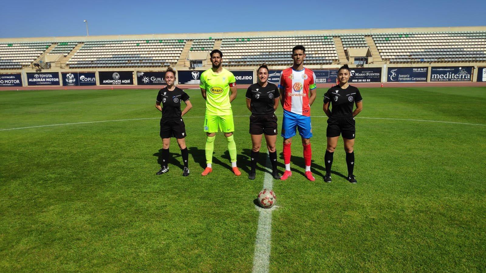 Los dos capitanes posan junto con el trío arbitral.
