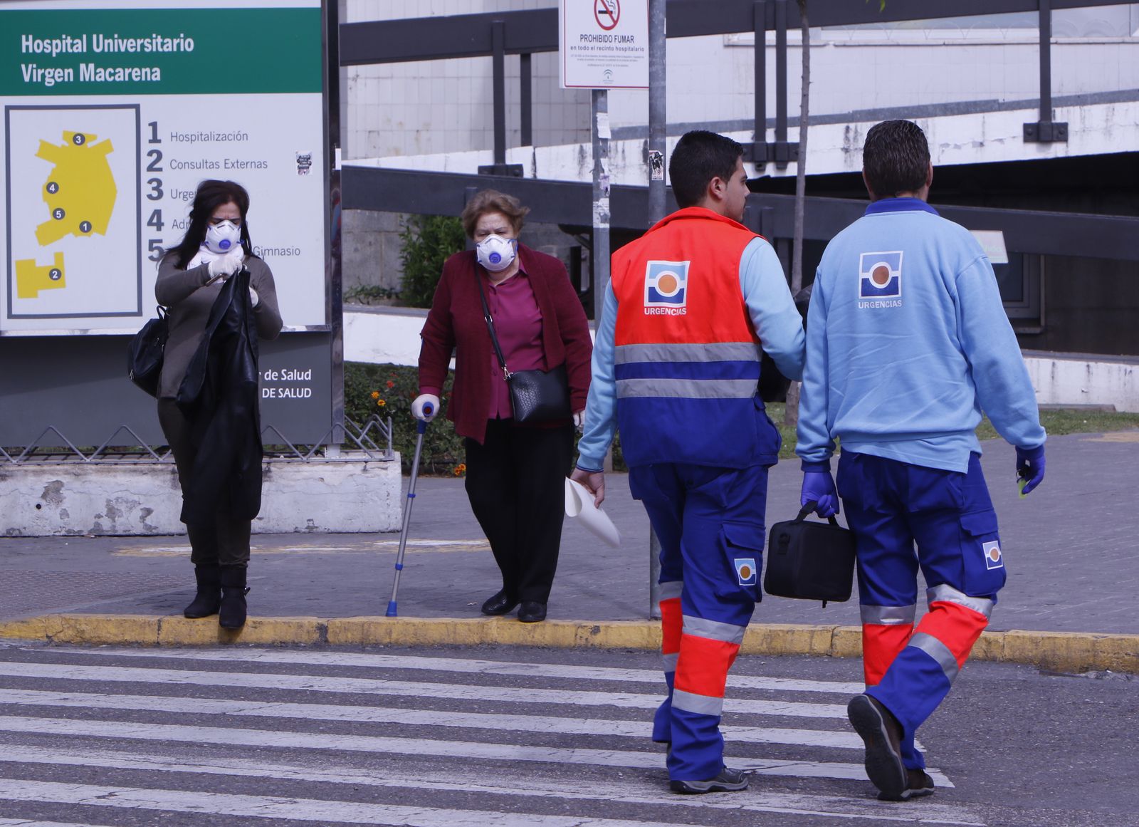 Dos mujeres con mascarillas salen del Hospital Macarena.