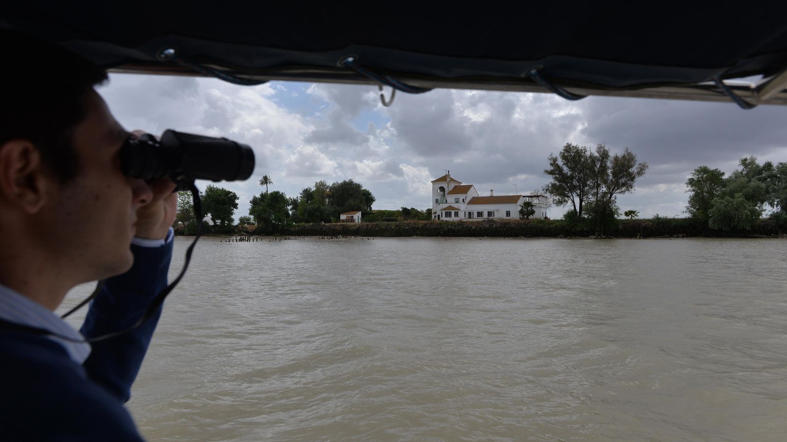 Marcos Pacheco mira con los prismáticos el Cortijo de La Compañía.