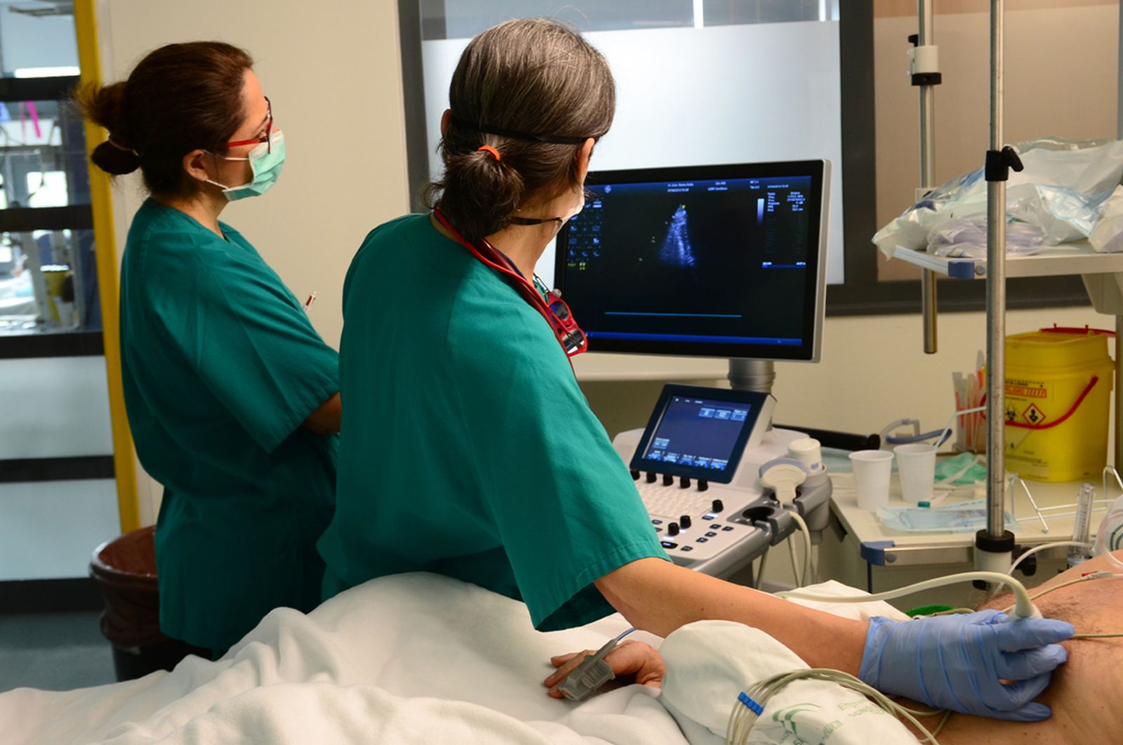 Dos profesionales del Reina Sofía realizan una ecografía a un paciente de la UCI.