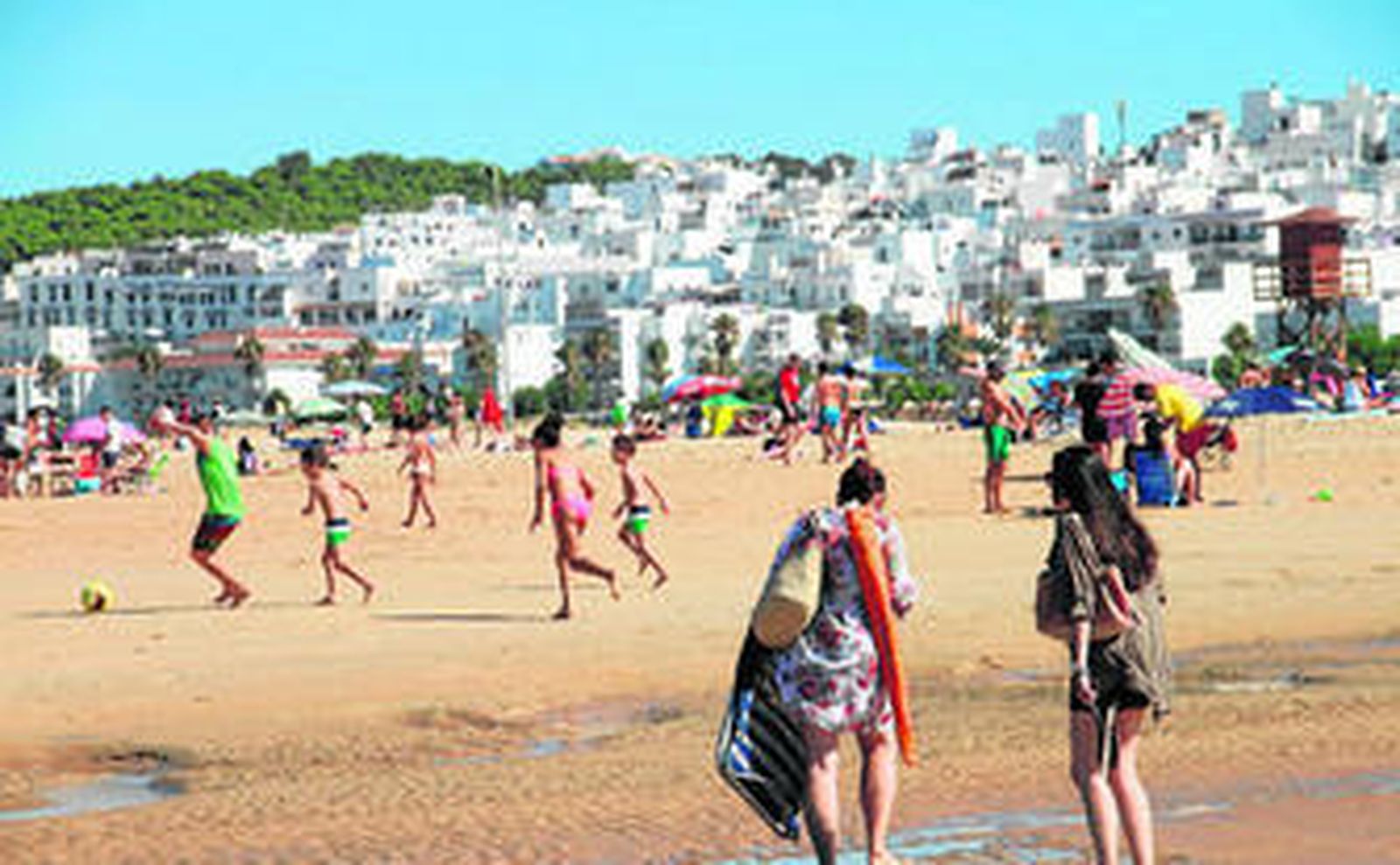 La playa de Los Bateles, repleta de turistas a primeras horas de la mañana. Al fondo Conil, con sus inconfundibles casas blancas.