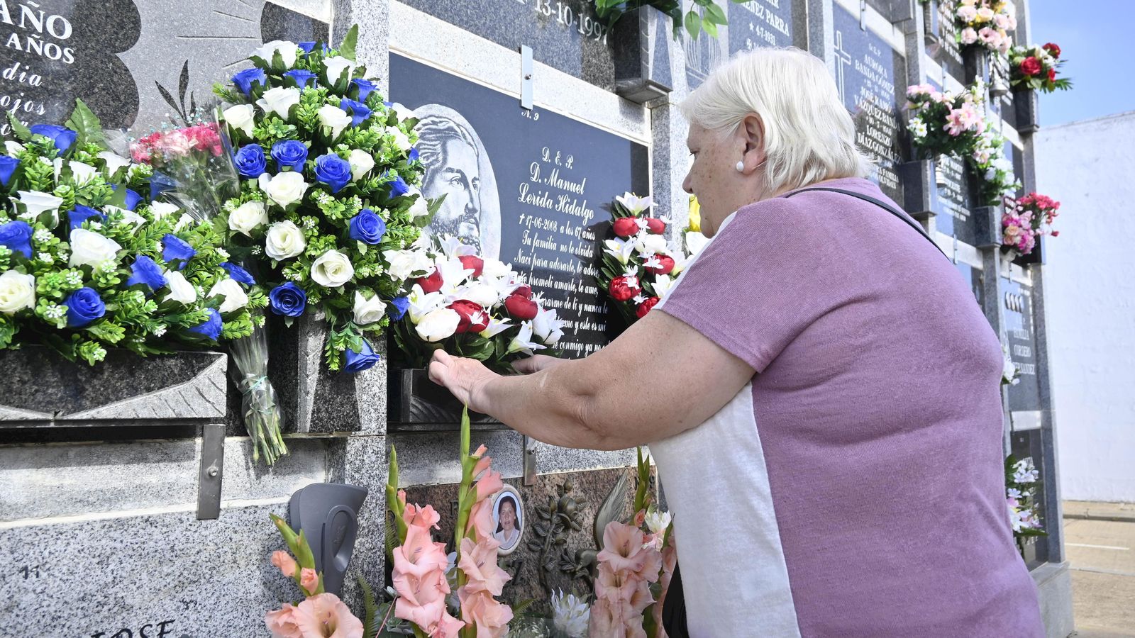 Ana cambia las flores de la última morada de su esposo, Manuel, fallecido en 2008.