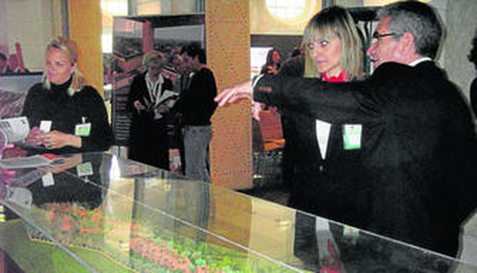 Un promotor muestra a una asistente a la feria una promoción de viviendas.