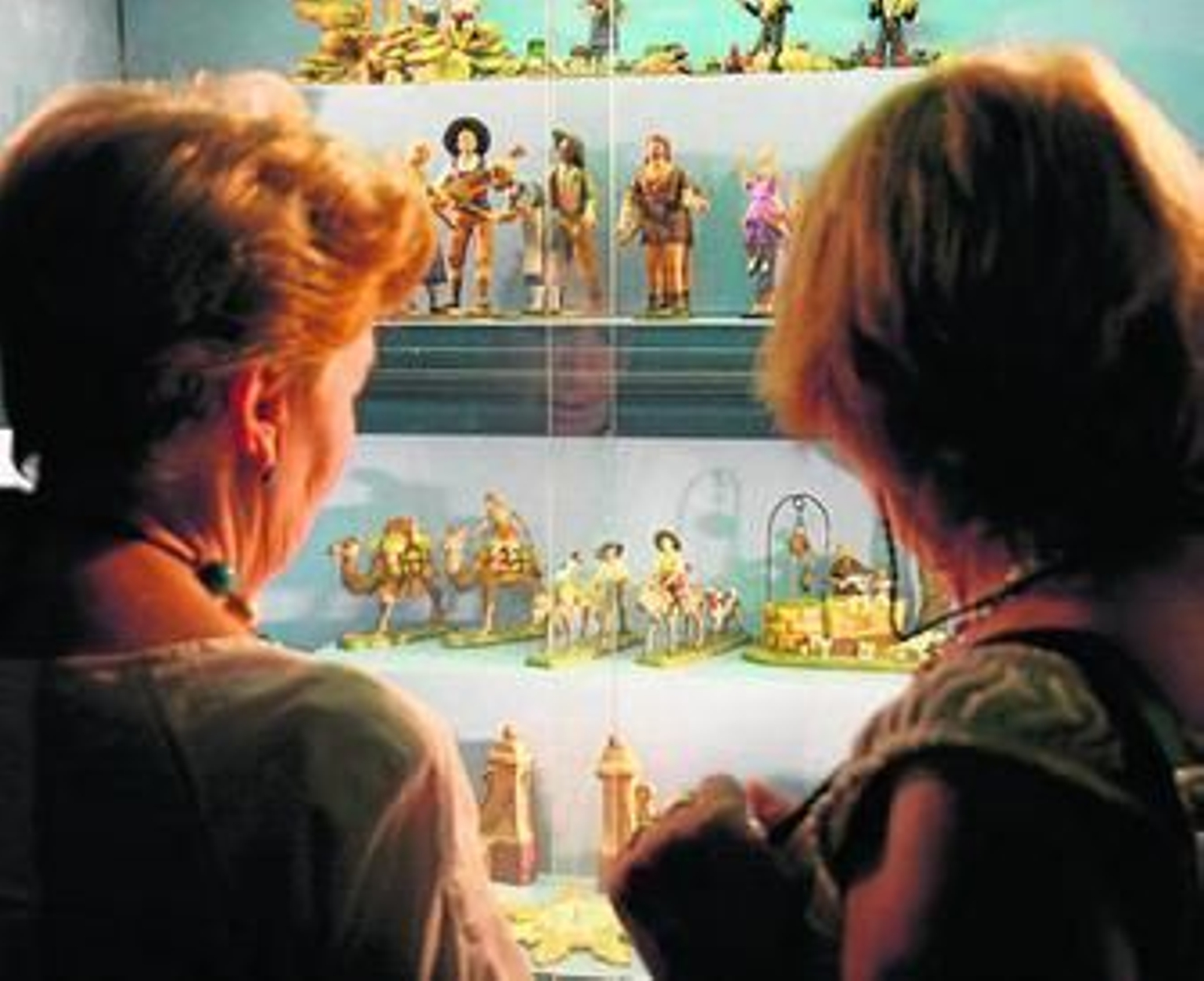 Algunas de las asistentes contemplan varias de las figuras expuestas.