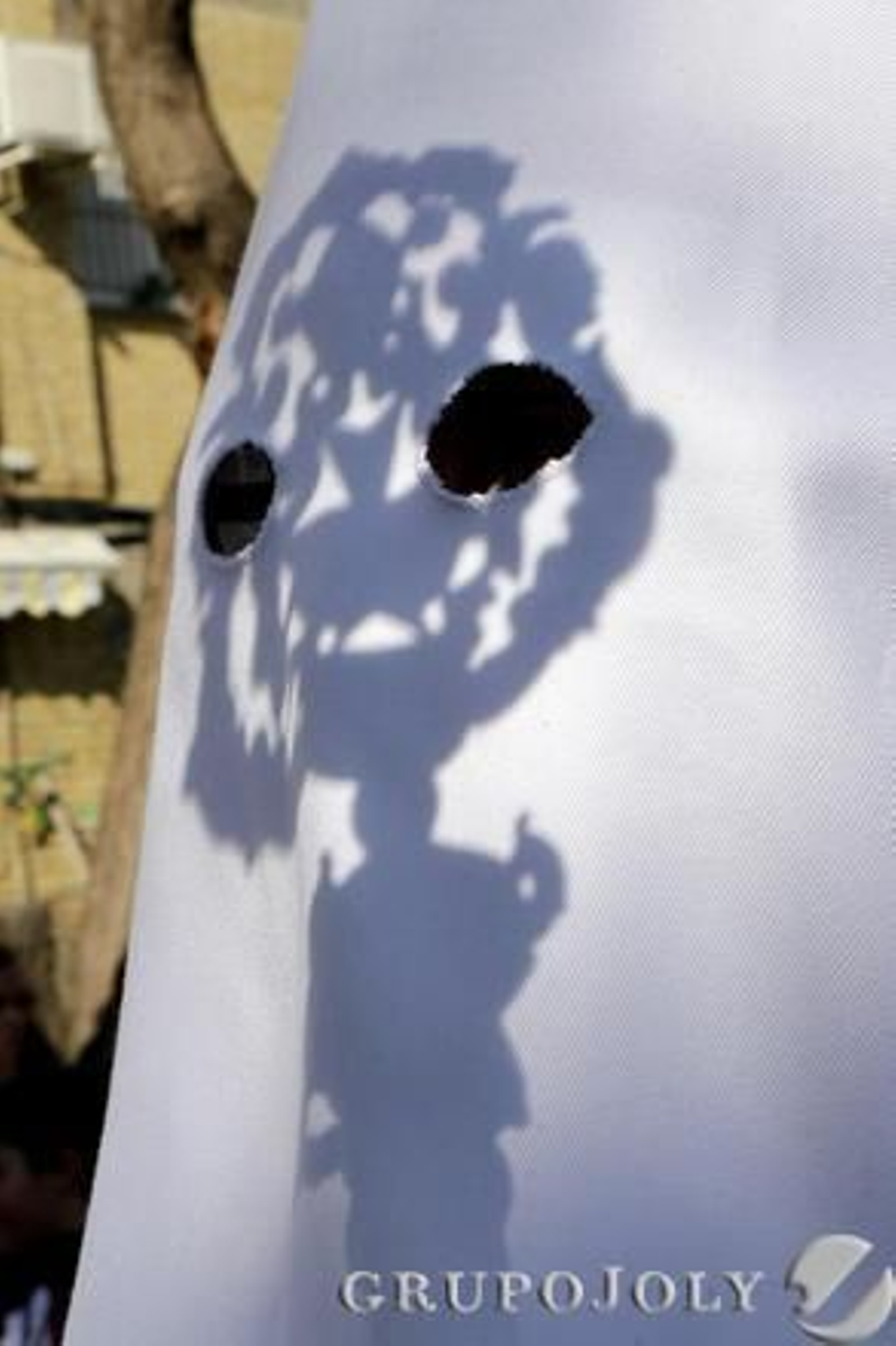 El escudo de la vara refleja su sombra sobre el antifaz de un hermano de La Clemencia.

Foto: Manuel Aranda