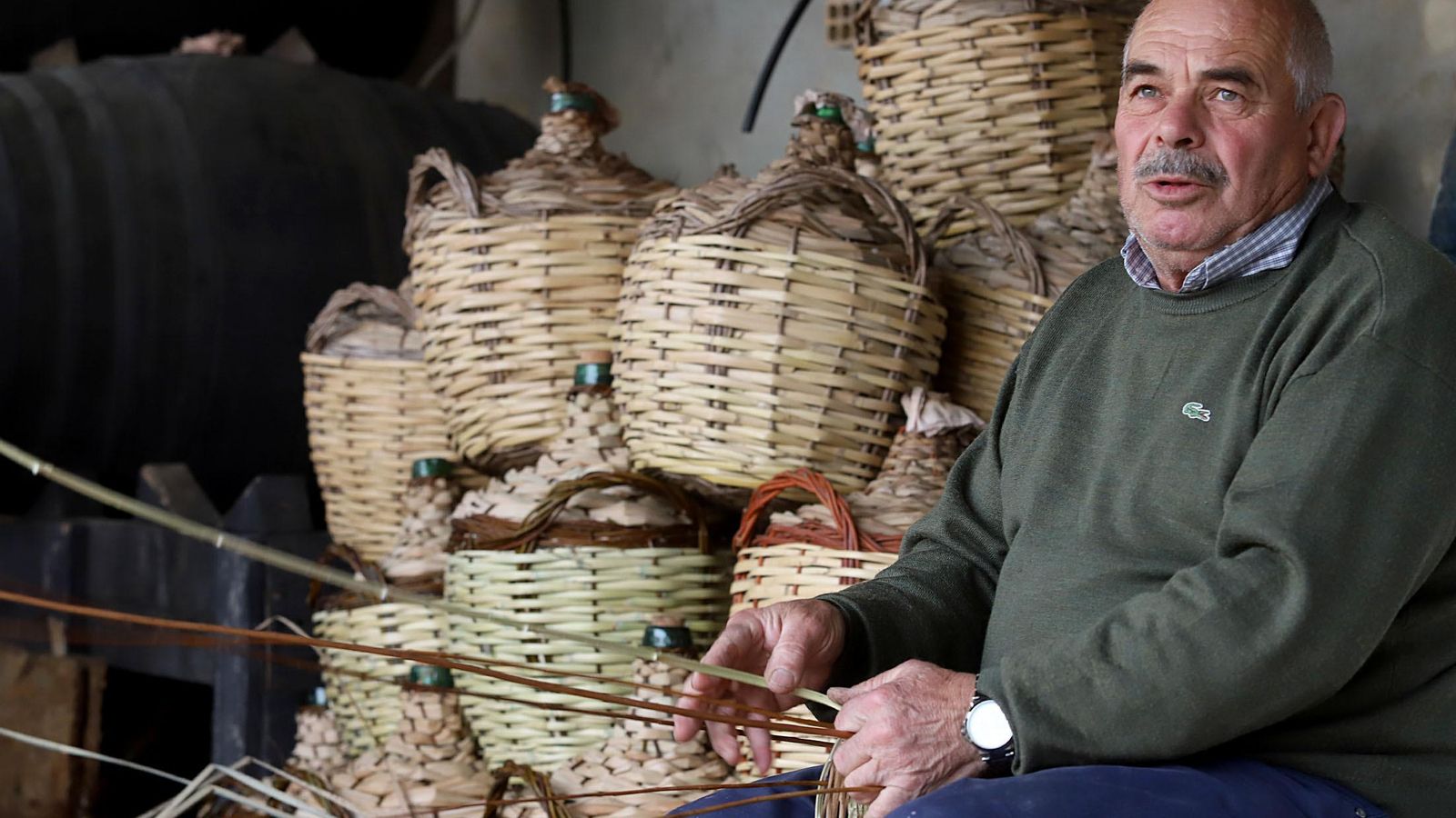 El artesano junto a las garrafas que acaba de terminar.