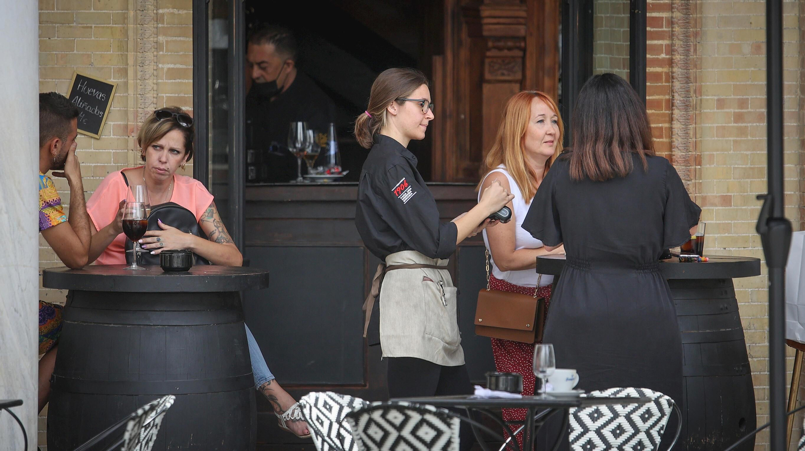 Una camarera atiende a unos clientes en el Gallo Azul.