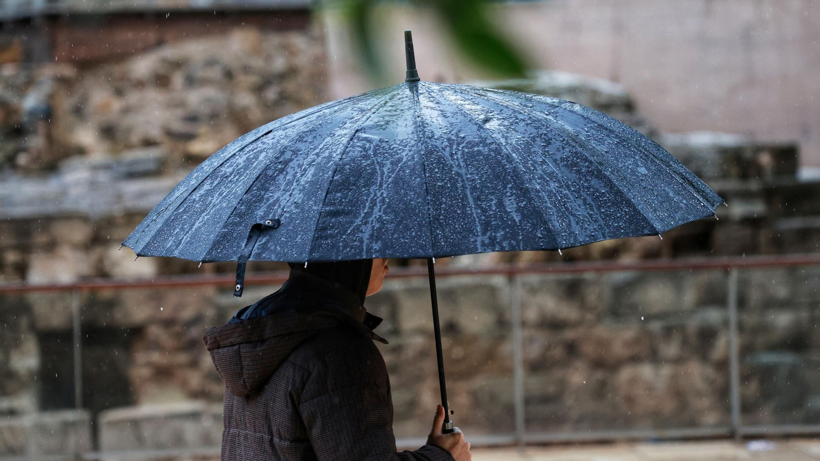 Un hombre paseando por el centro de Málaga en un día lluvioso