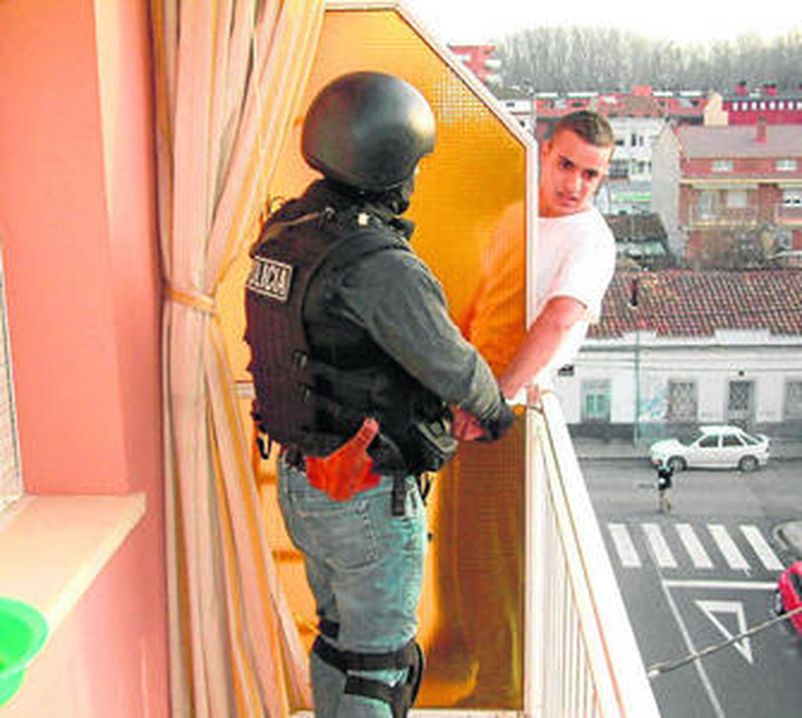 Un policía esposa ayer a Mohamed Larbi cuando intentaba fugarse por la ventana en un piso de Lérida.