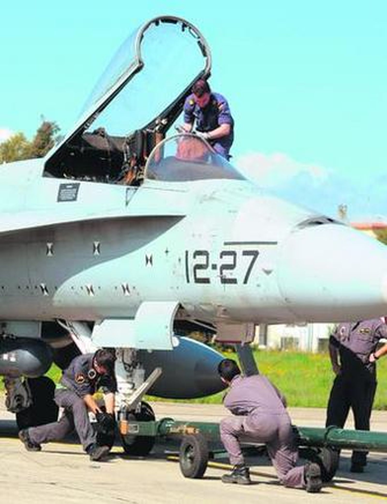 Varios técnicos revisan un avión en Decimomannu.