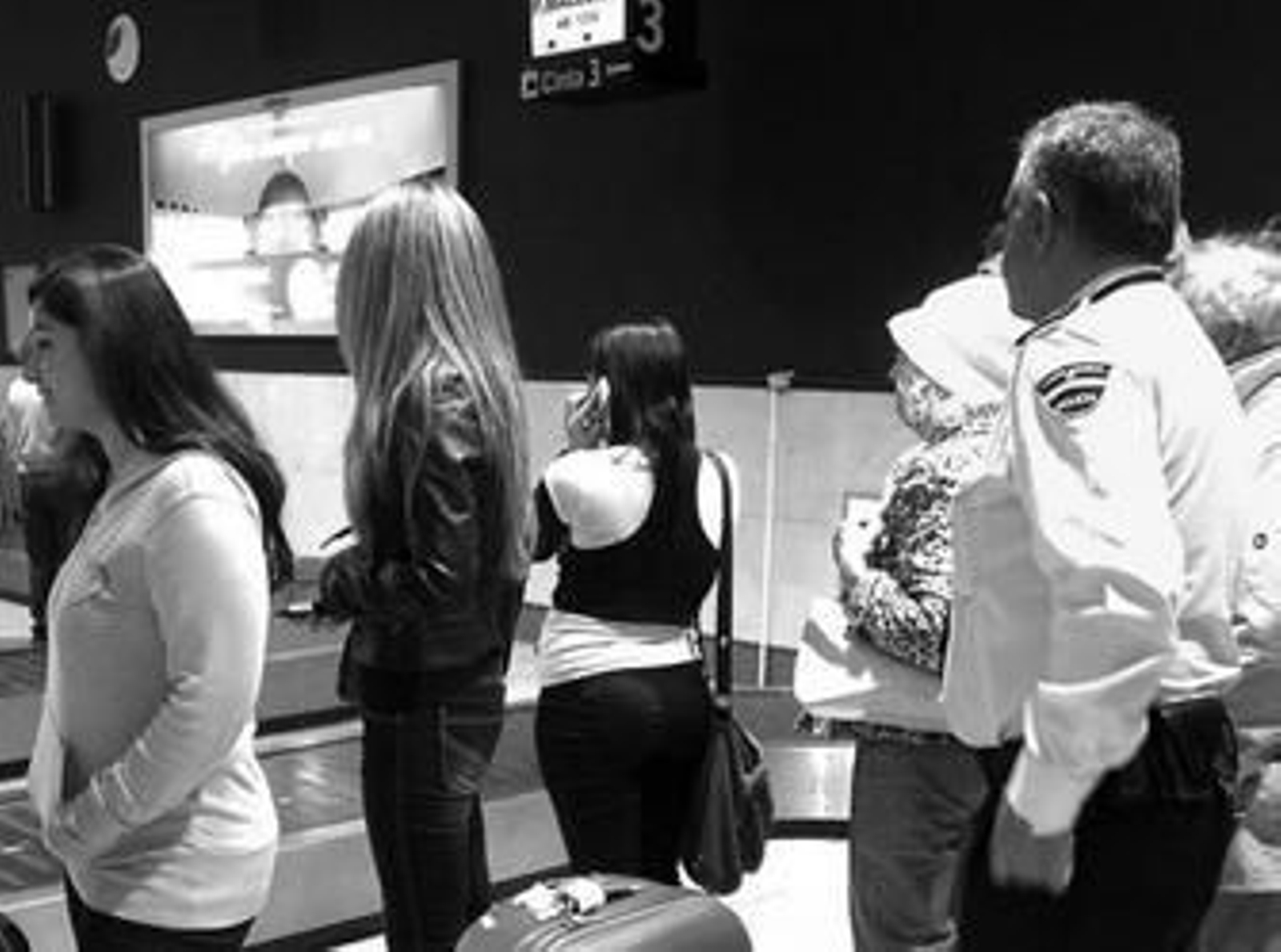 Un policía del aeropuerto controla el equipaje de los viajeros para evitar la entrada de drogas.