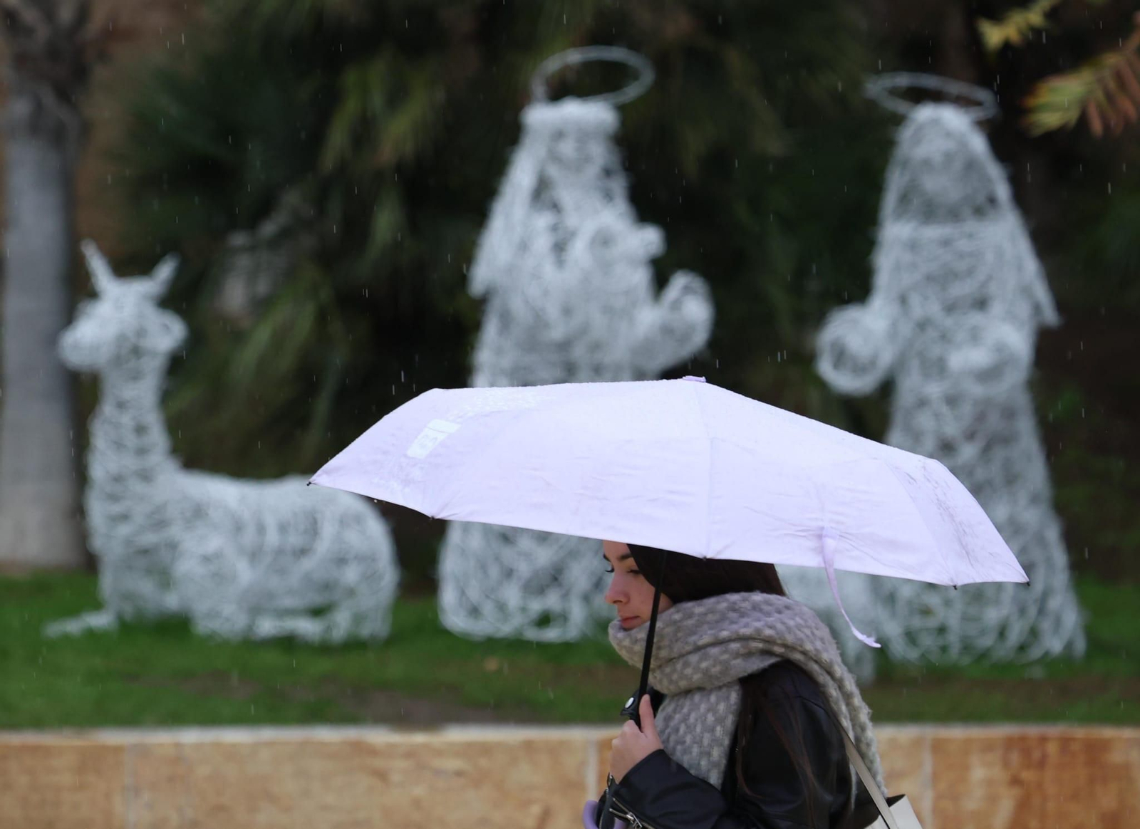 Una mujer se protege de la lluvia este jueves en la capital. Una mujer se protege de la lluvia este jueves en la capital.