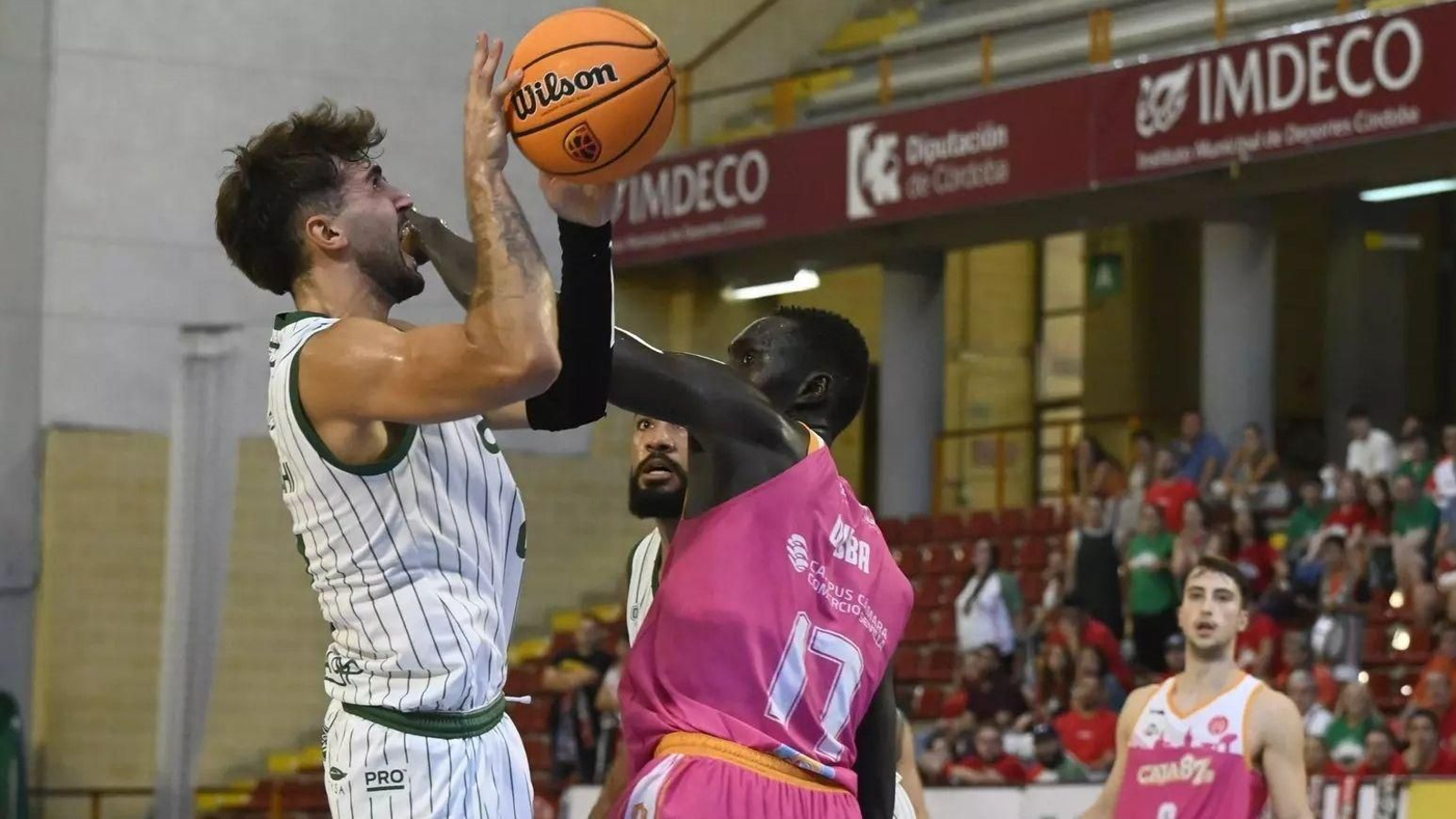 Fernando Bello, del Coto Córdoba, trata de lanzar a canasta ante la oposición de Dibba, pívot del Cajasol 87.