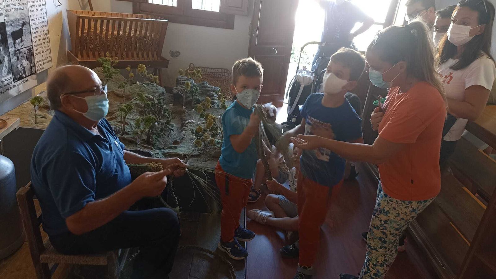 Un experto en el uso del esparto muestra a los niños cómo se puede utilizar.