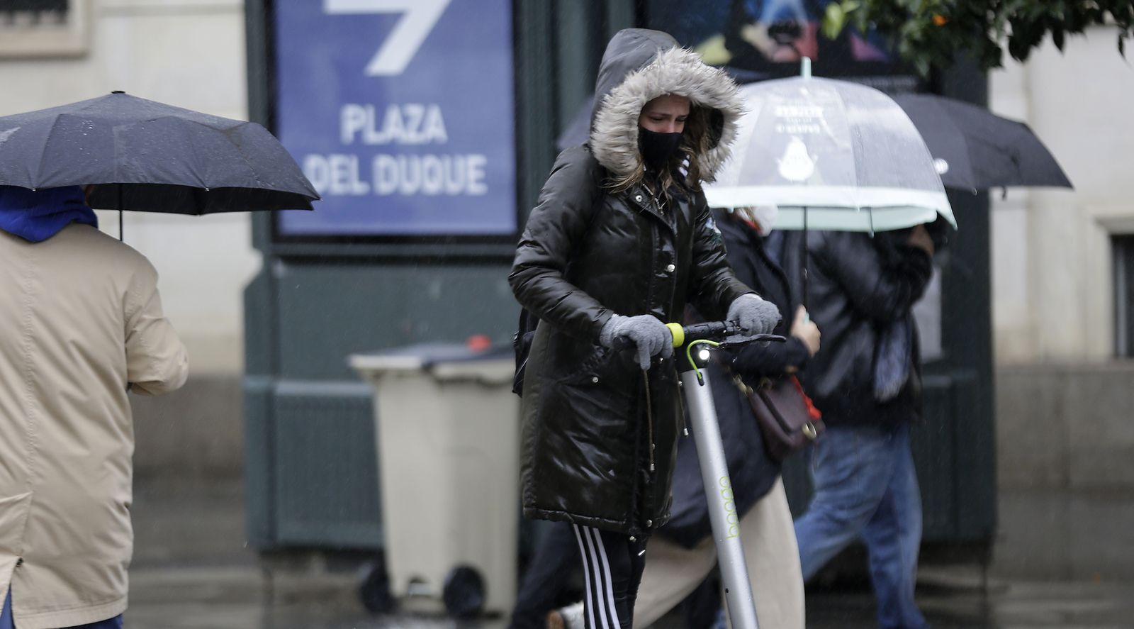 Una mujer circula en patinete en una mañana fría.
