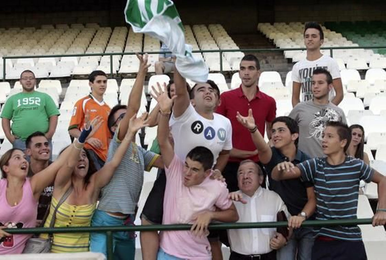 Varios aficionados béticos tratan de alcanzar la camiseta de Miguel Lopes.

Foto: Juan Carlos Muñoz