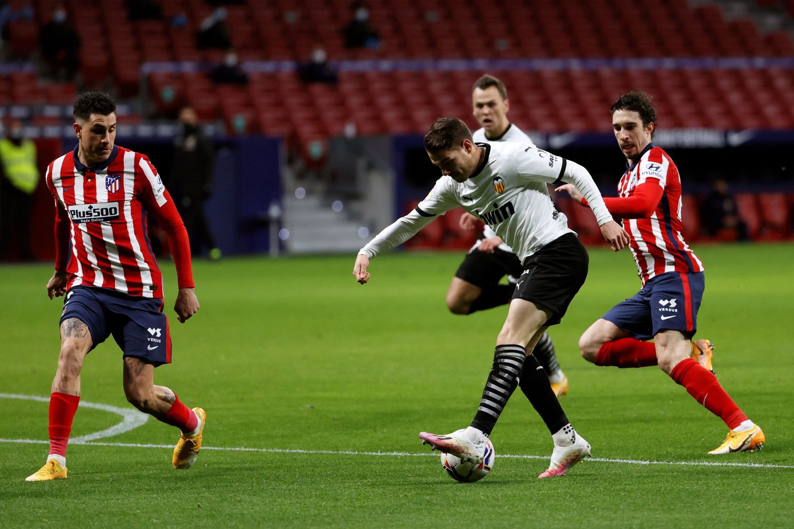 Manu Vallejo controla el balón ante Giménez y Vrsaljko.