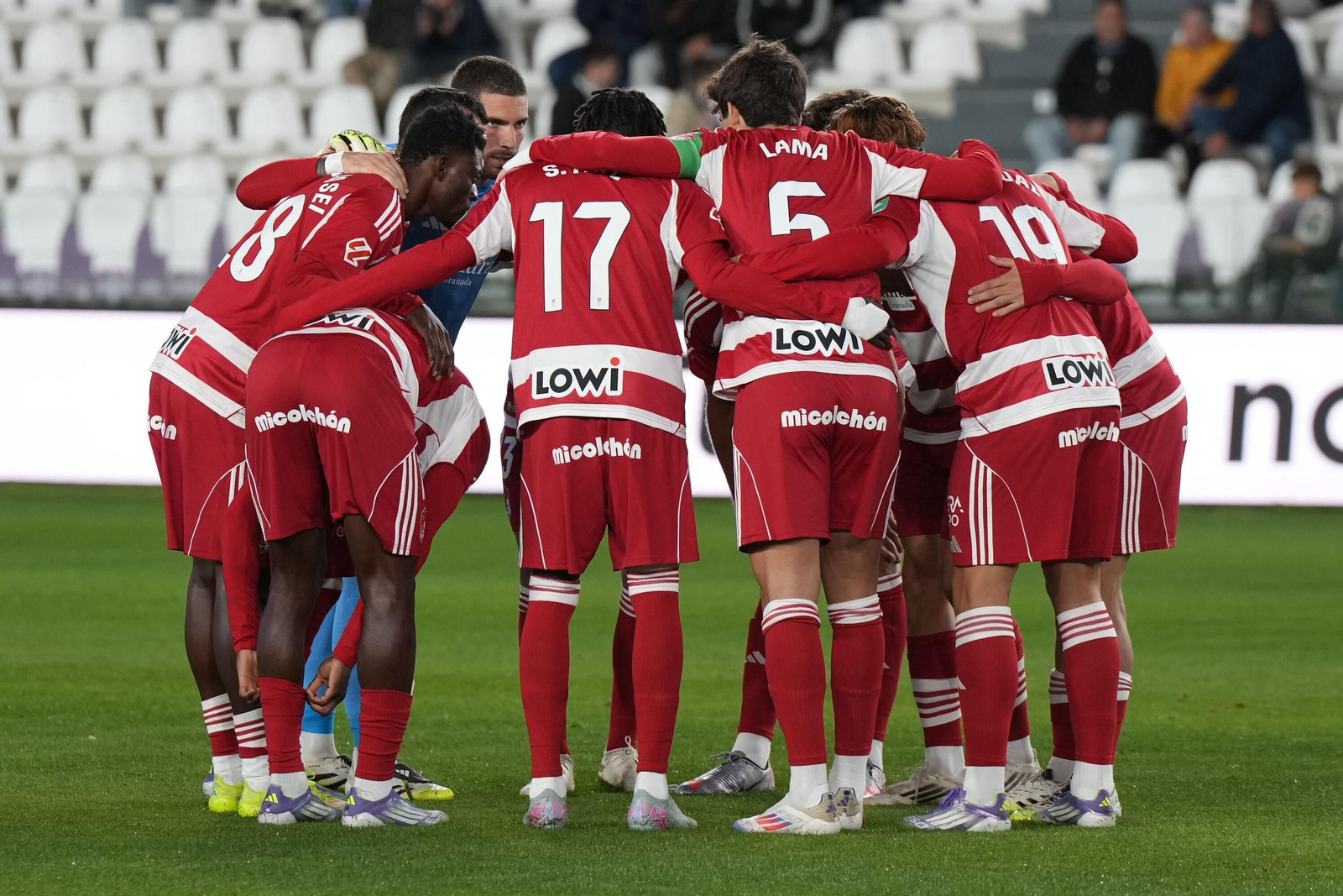 Piña de jugadores del Granada antes del partido ante el Burgos
