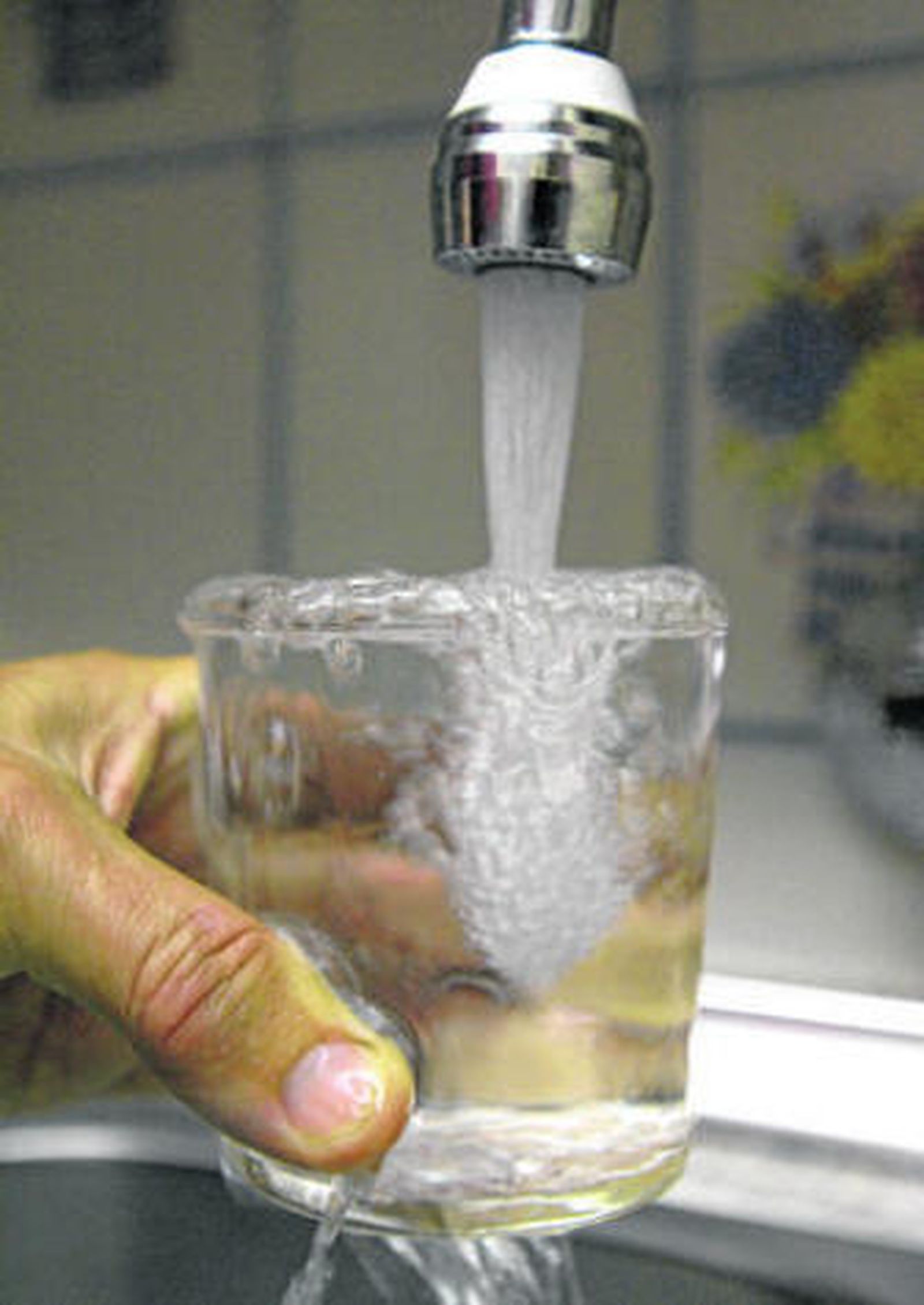 Imagen de un vecino llenando un vaso de agua.