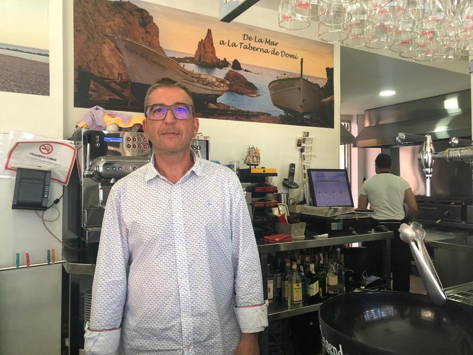 Domingo García tras la barra de la taberna.