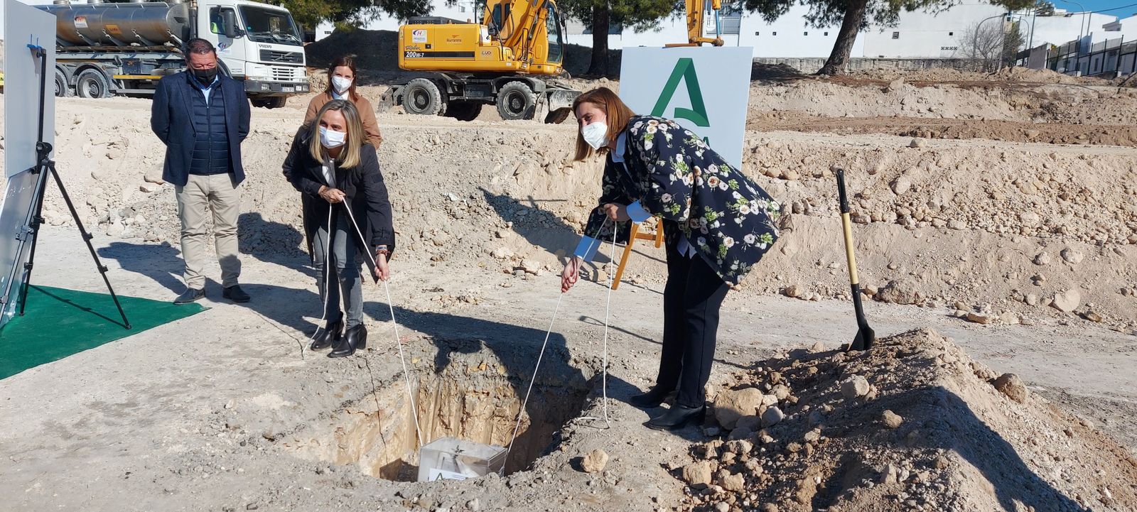 La consejera y la alcaldesa ponen la primera piedra.