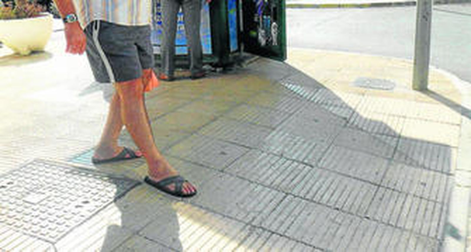 1. En la imagen se distingue la pronunciada pendiente con la que cuenta la rampa mientras pasea por ella un peatón 2. Un vecino de la zona, como protesta contra la obra, trata de demostrar cuál es el peligro de esta construcción.  3. Algunos vecinos ya optan por esquivar la rampa. 4. El centro de mayores se encuentra al lado.