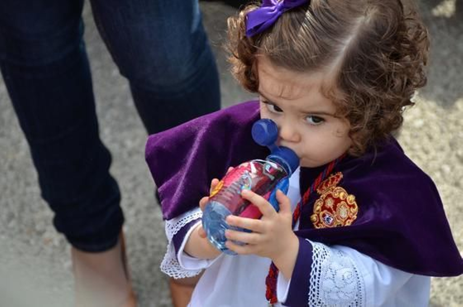 Reponiendo fuerzas. Una guapa monaguilla de la Hermandad de La Candelaria bebe agua mientras mira de reojo al palio.

Foto: Manuel Aranda