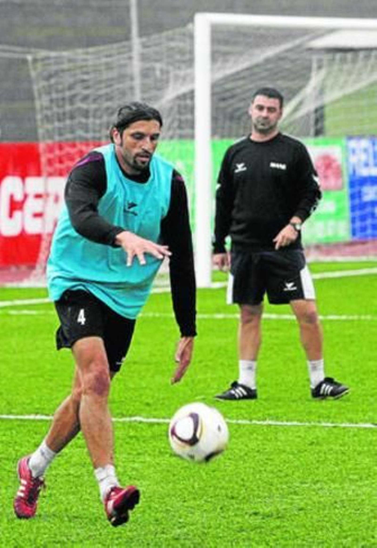 Alberto Merino bota el balón en el entrenamiento de ayer; al fondo le observa Mane.