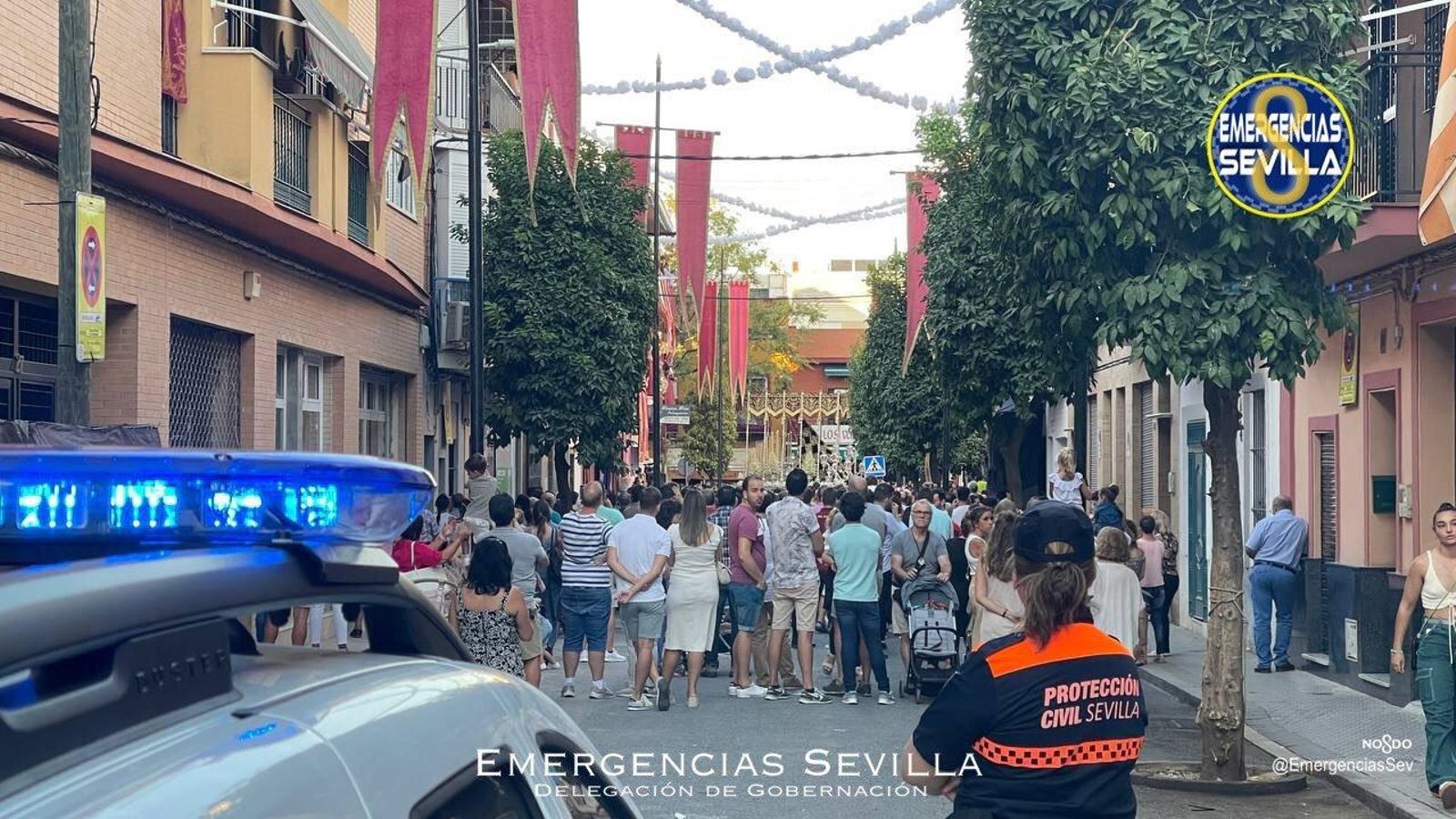 Agentes de Policía Local de Sevilla y voluntarios de Protección Civil durante la procesión