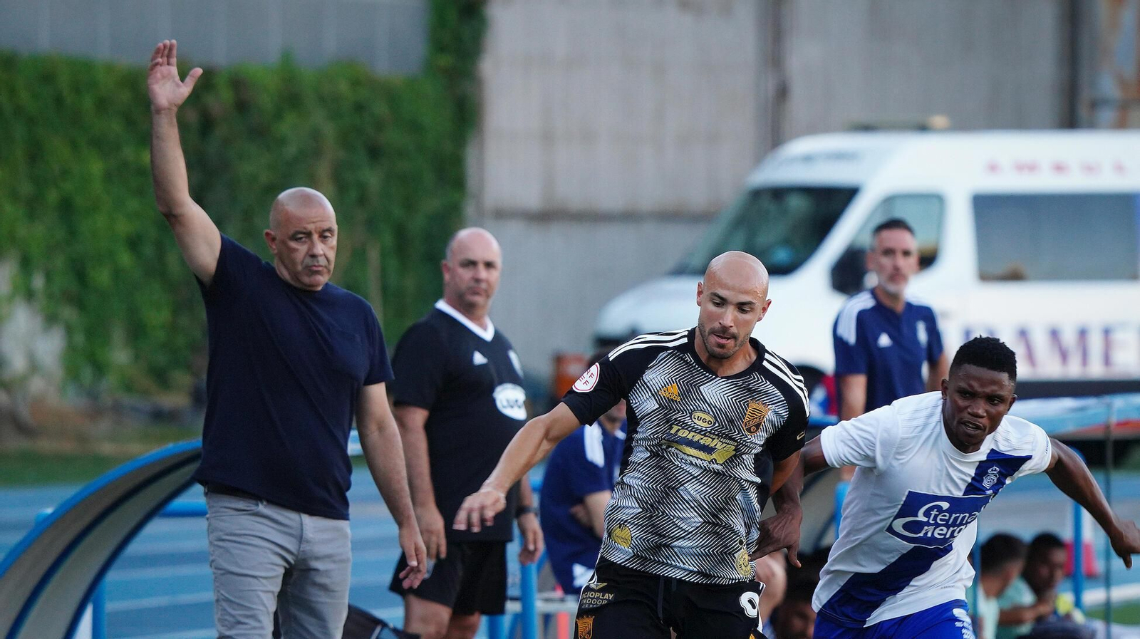 Paco Peña levanta la mano, mientras Lobo lucha por un balón.