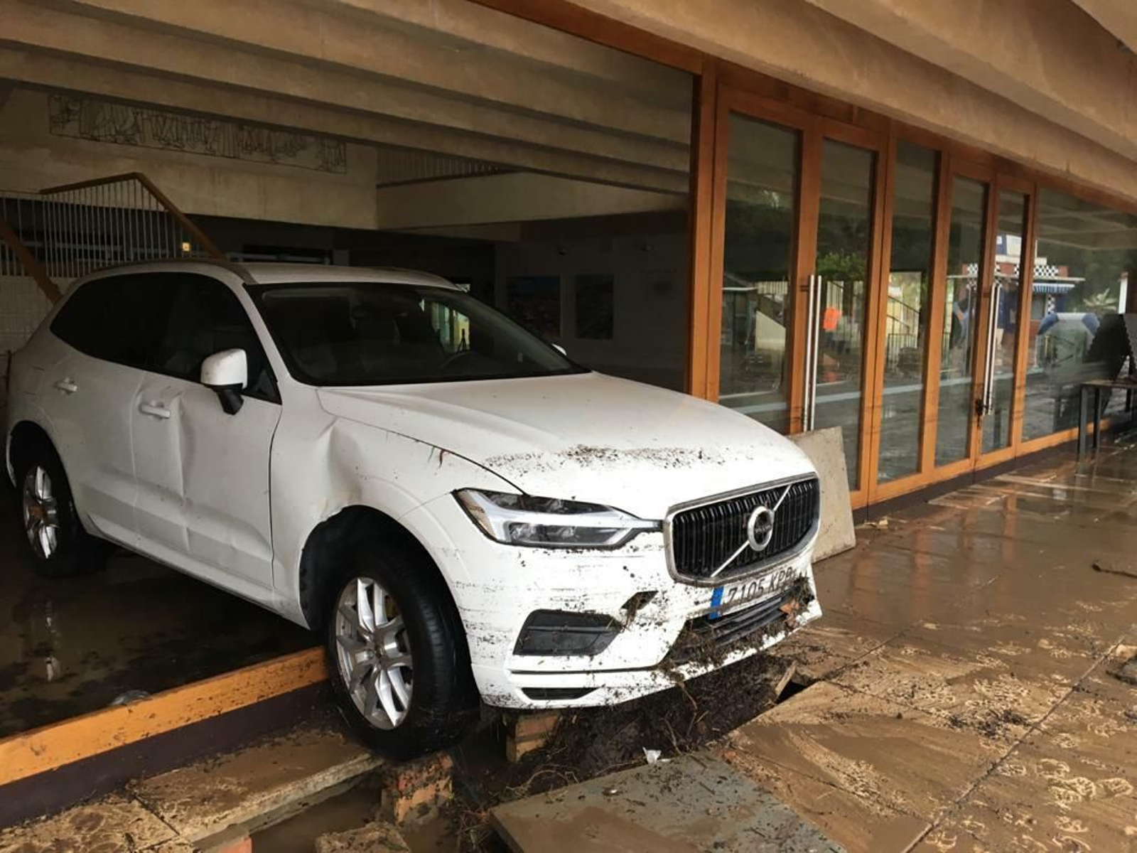 Un vehículo empotrado en el teatro municipal por la riada de agua.