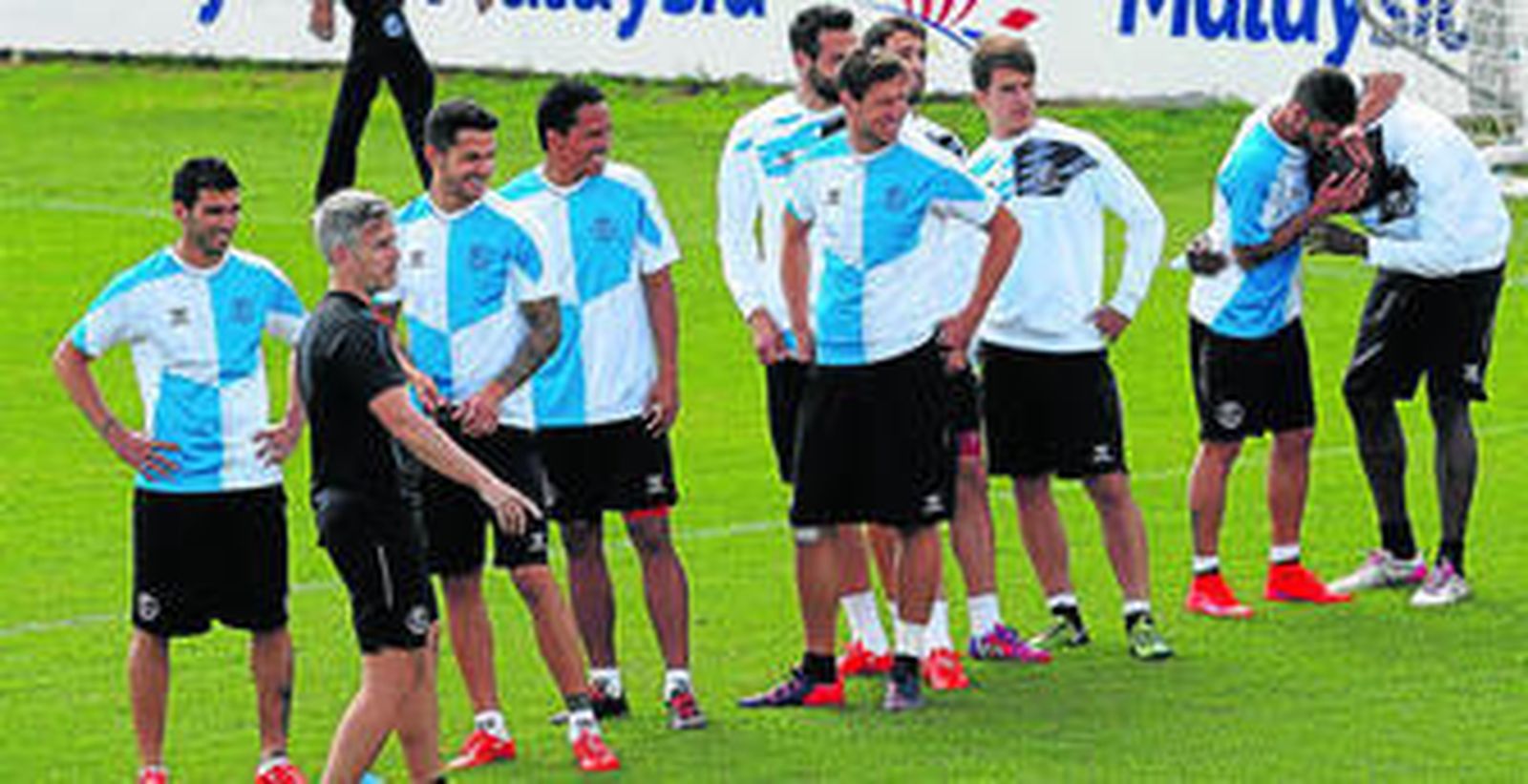 Reyes, Vitolo, Bacca, Krychowiak, Iborra, Pareja y Denis Suárez sonríen mientras Diogo Figueiras bromea con Mbia.