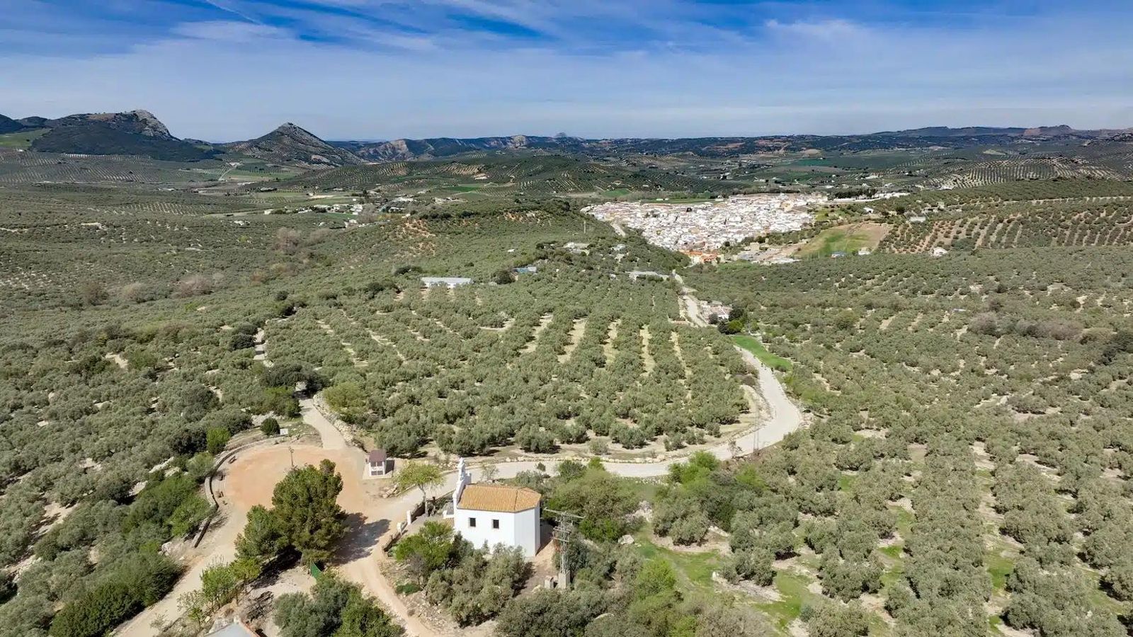 La Ermita de Nuestra Señora del Rosario y, a lo lejos, Villanueva del Rosario.