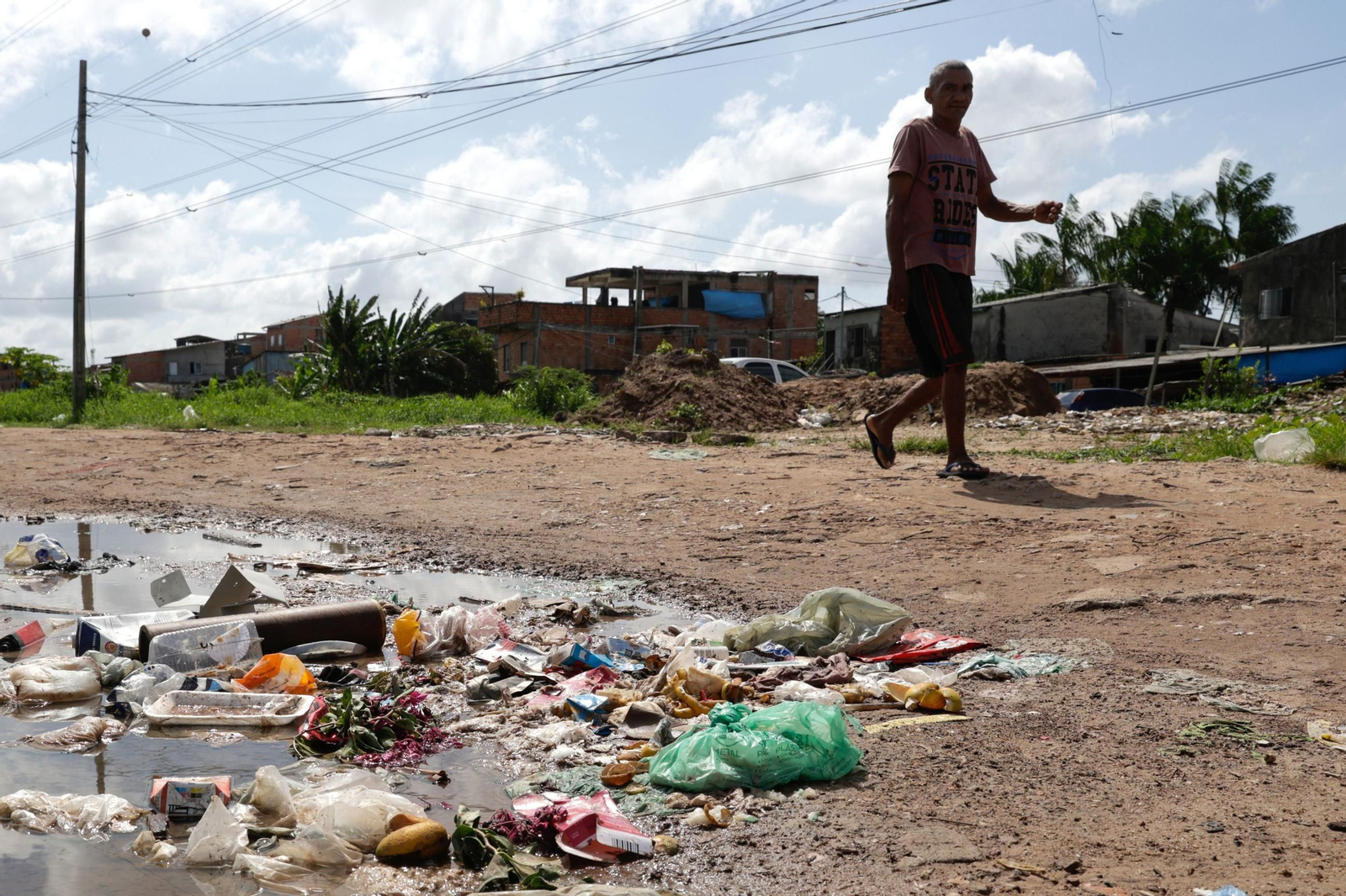 Una persona camina junto a basura acumulada en una zona del barrio Maracangalha, cerca del aeropuerto de Belem. Una persona camina junto a basura acumulada en una zona del barrio Maracangalha, cerca del aeropuerto de Belem.