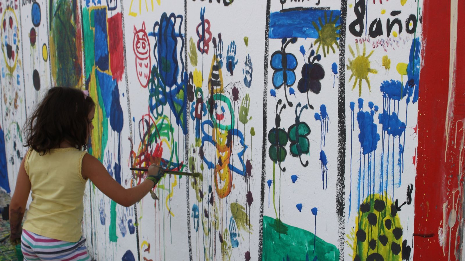 Una niña participa en la actividad de pintura al aire libre.