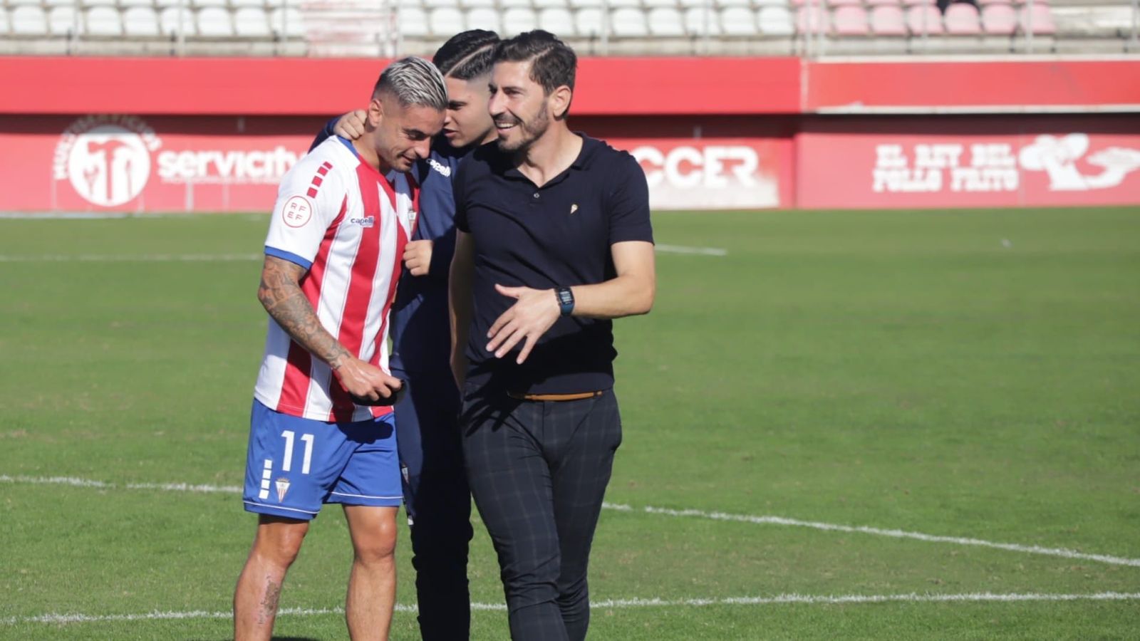 Javi Vázquez, sonriente junto a Tomás, felicitado por un compañero.