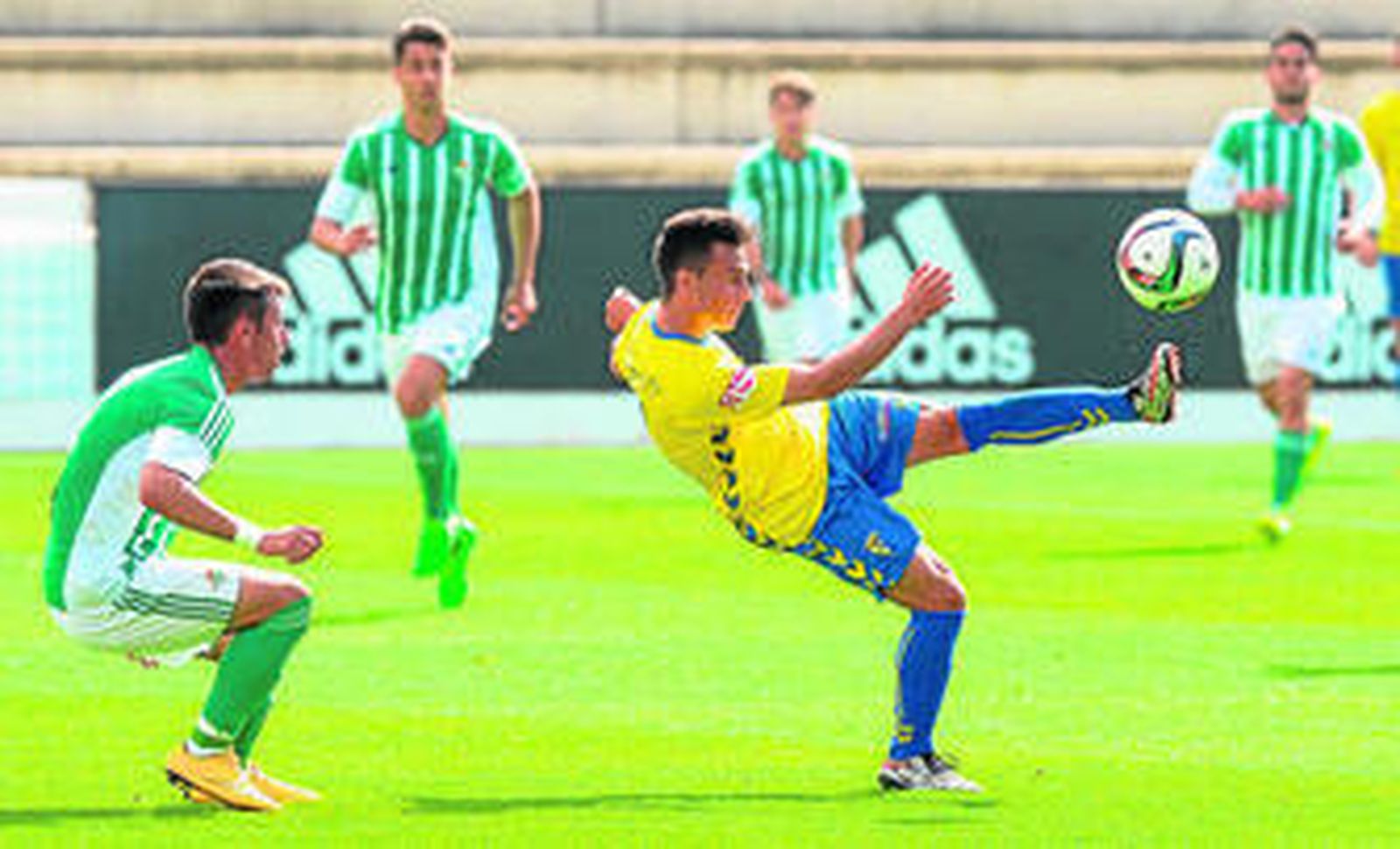 Álvaro García golpea el balón rodeado por varios jugadores del Betis B.