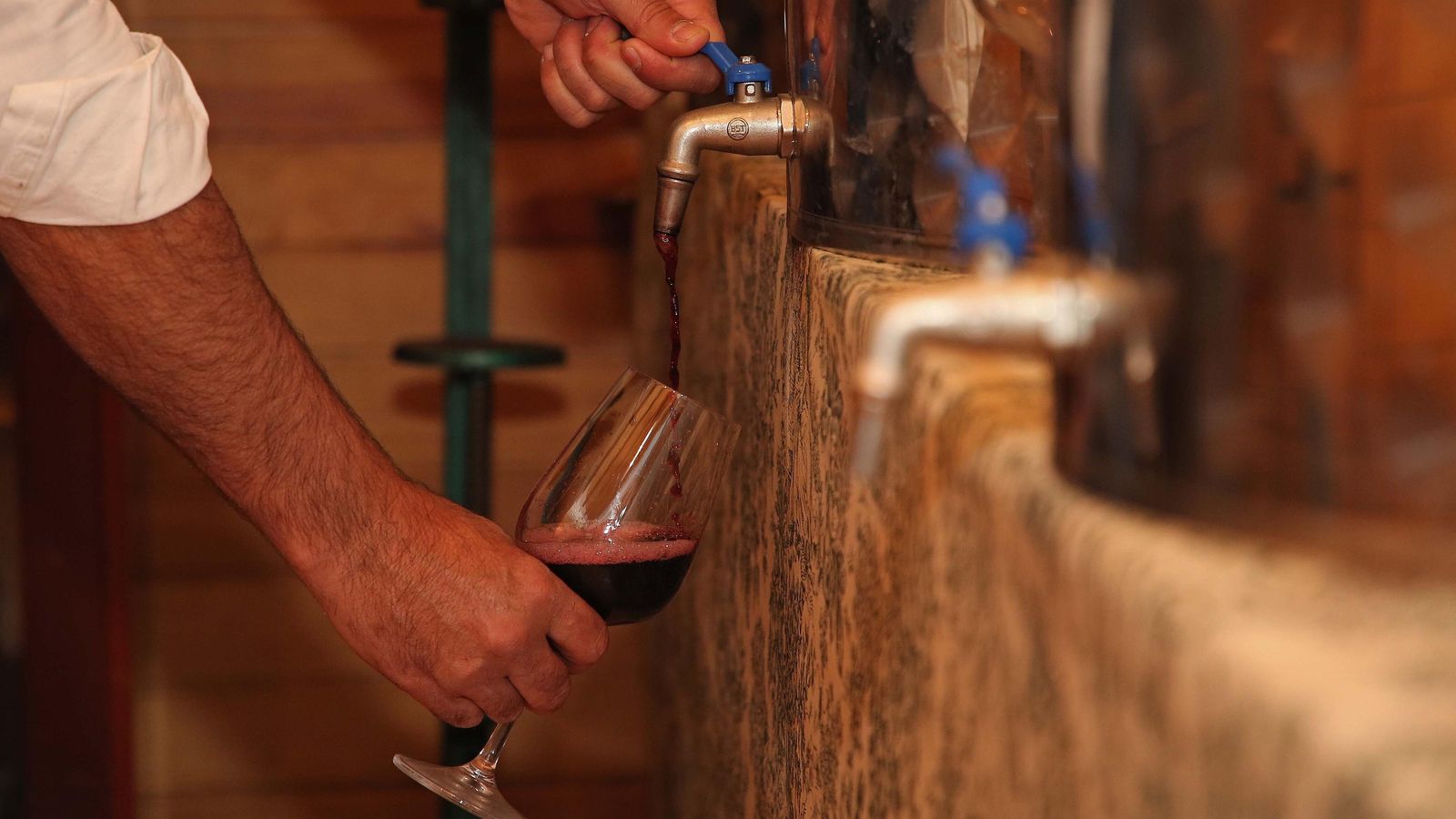 Rafael García llena una copa de vino en el antiguo guadarnés de la finca.