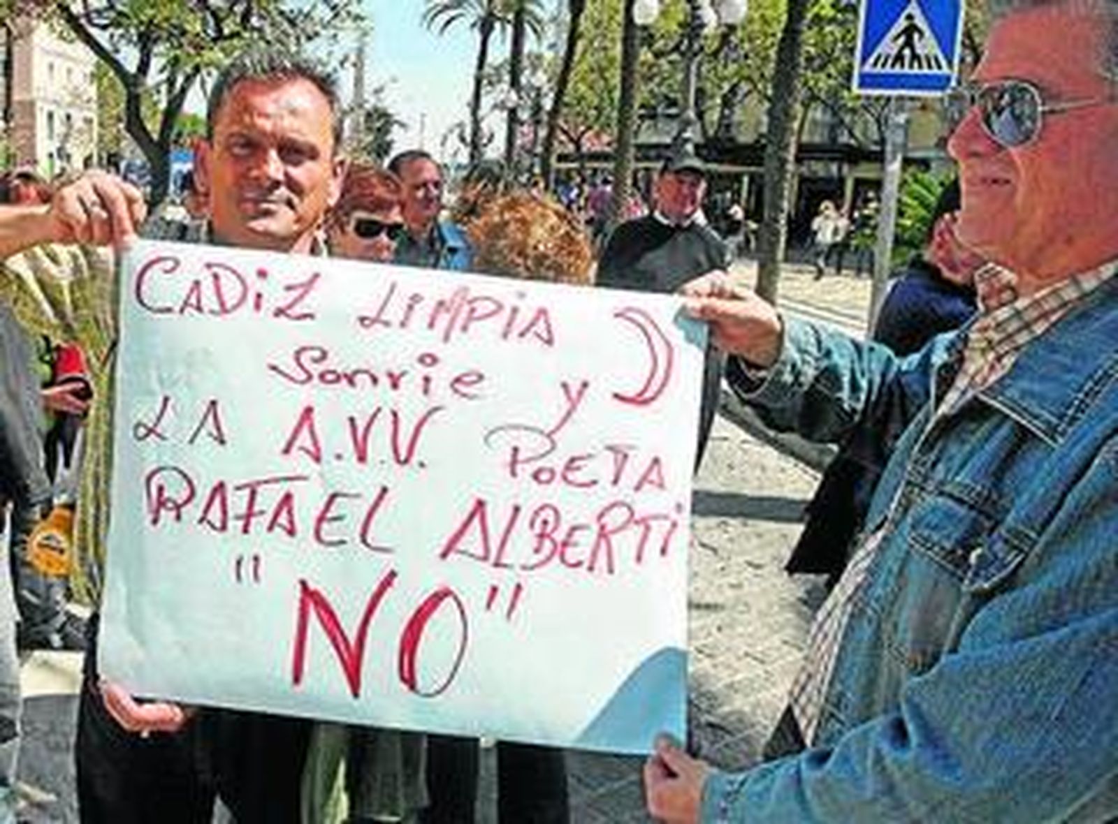 Vecinos con un cartel reivindicativo ayer frente al Ayuntamiento.