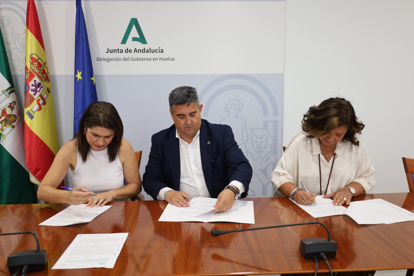 Firma de la cesión de la parcela entre los delegados Lucía Núñez, José Manuel Correa y Carmen Céspedes.