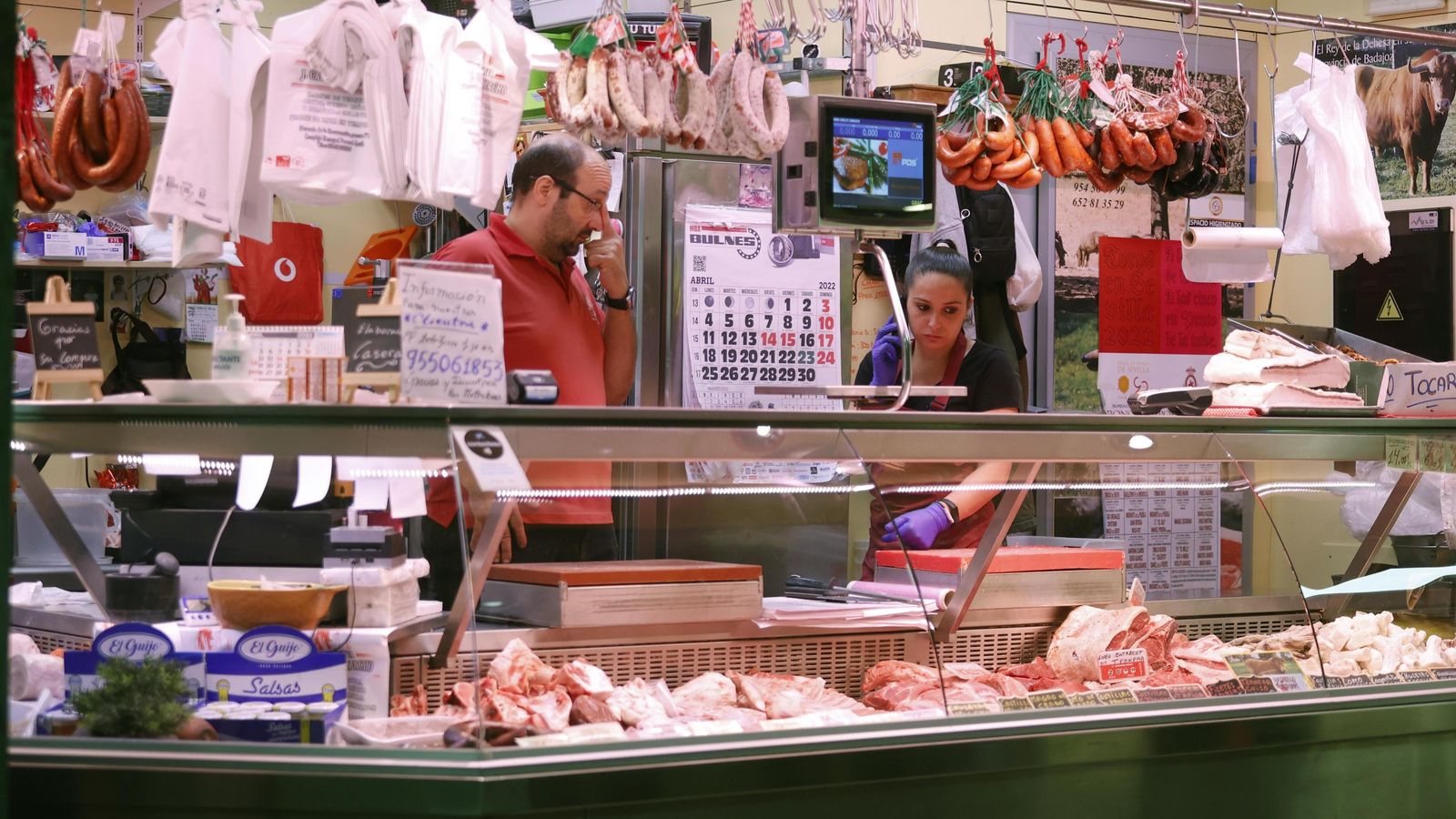 Dos dependientes, sin mascarilla en un puesto sin clientes.