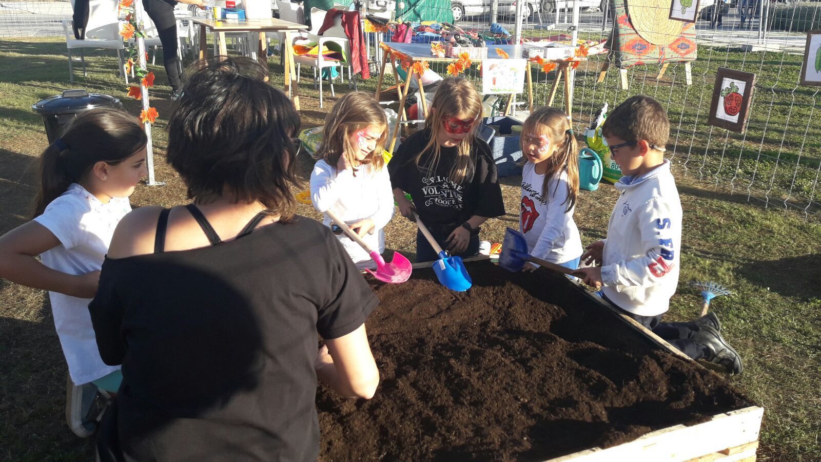 Varios niños cuidando de un huerto urbano.
