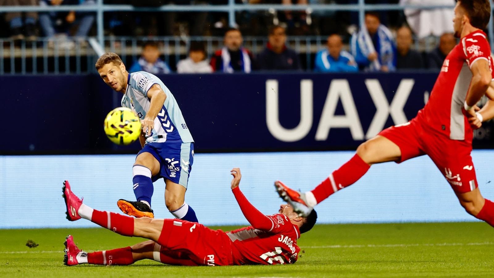Albarrán trata de frenar un centro de Brasanac en el primer tiempo del Málaga - Córdoba CF.