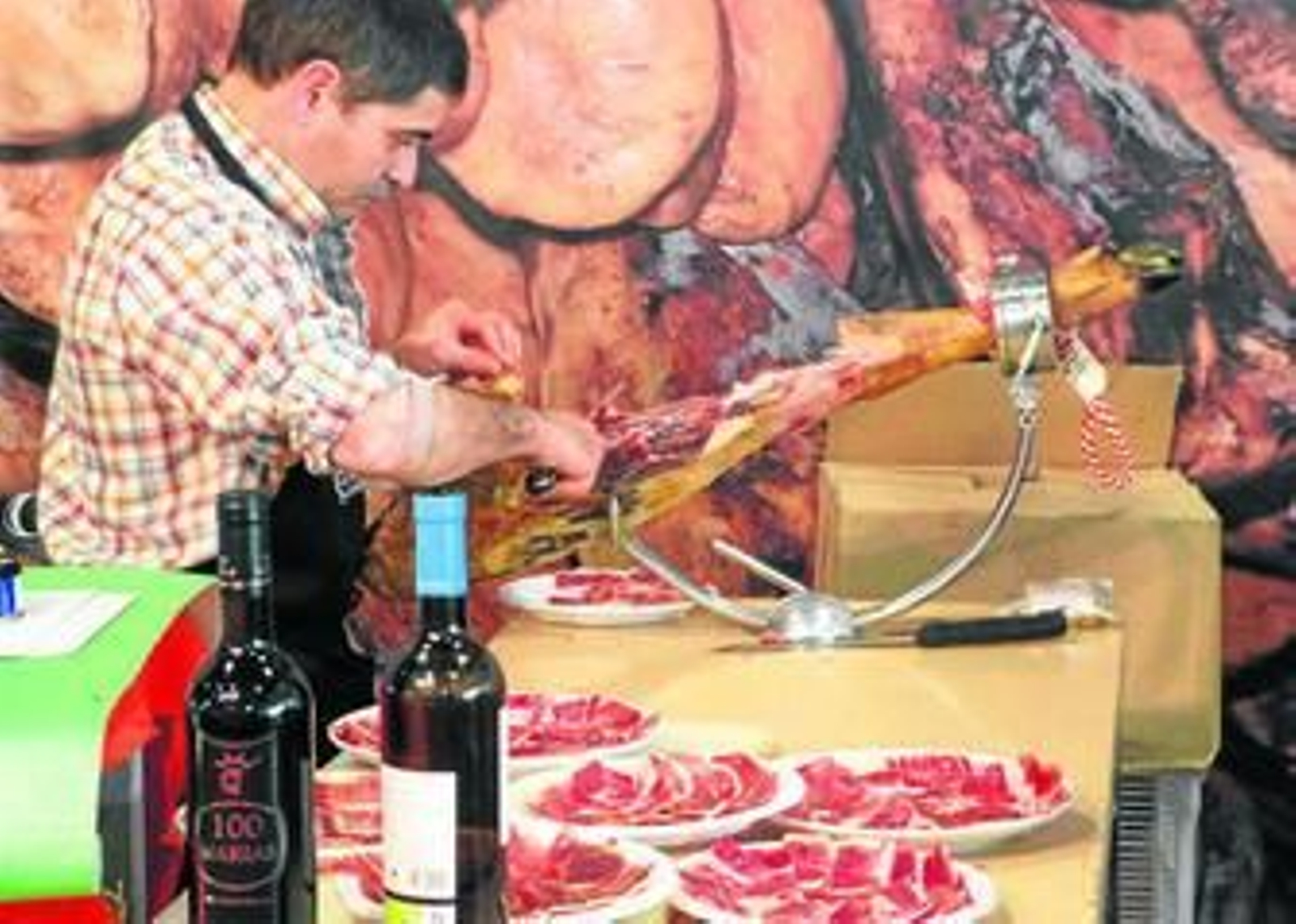 Un cortador prepara varios platos de jamón en el arranque ayer de la feria aracenense.